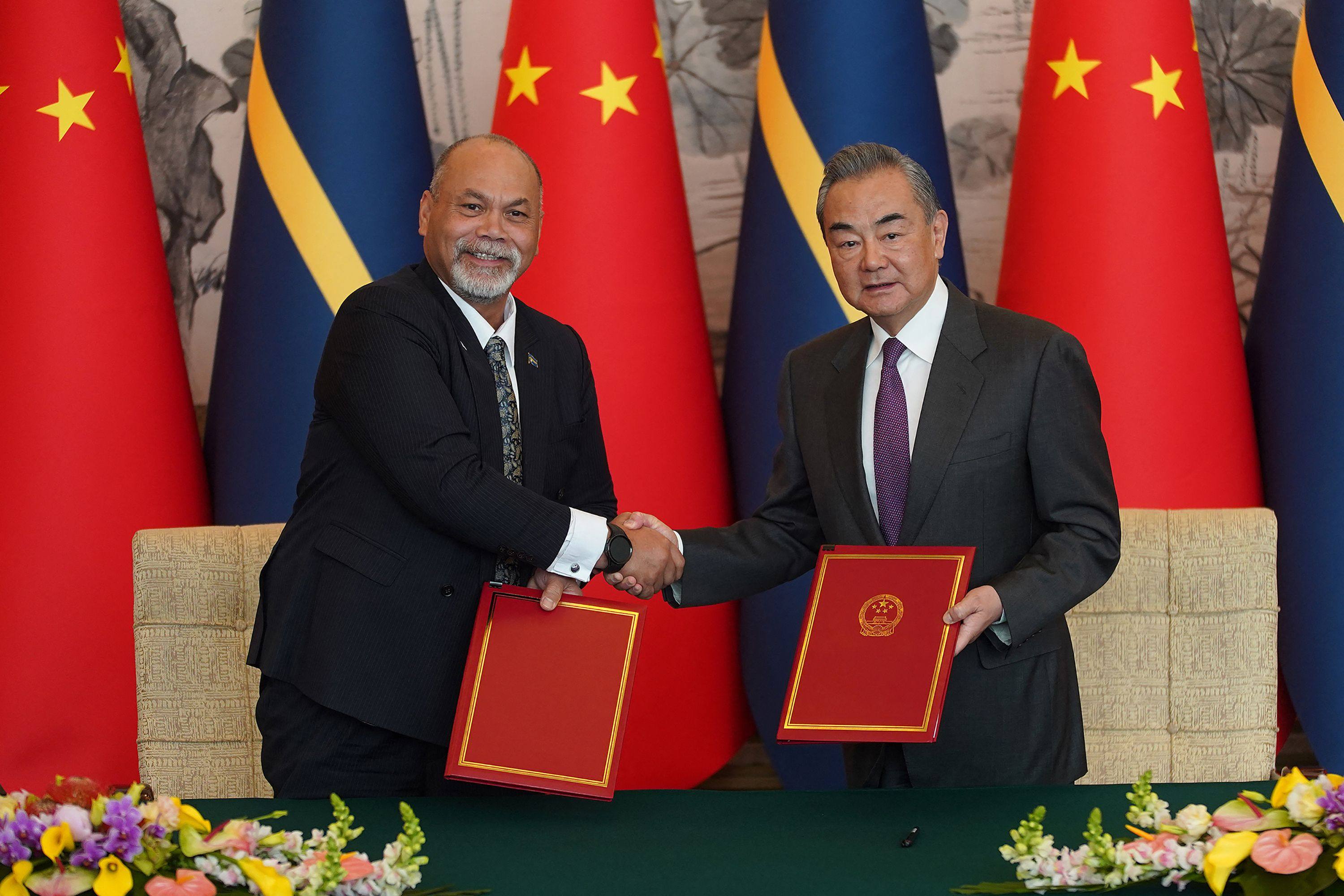 Nauru’s foreign minister Lionel Aingimea, left, shakes hands with China’s Foreign Minister Wang Yi after signing the joint communiqué on the resumption of diplomatic relations. Photo: AFP
