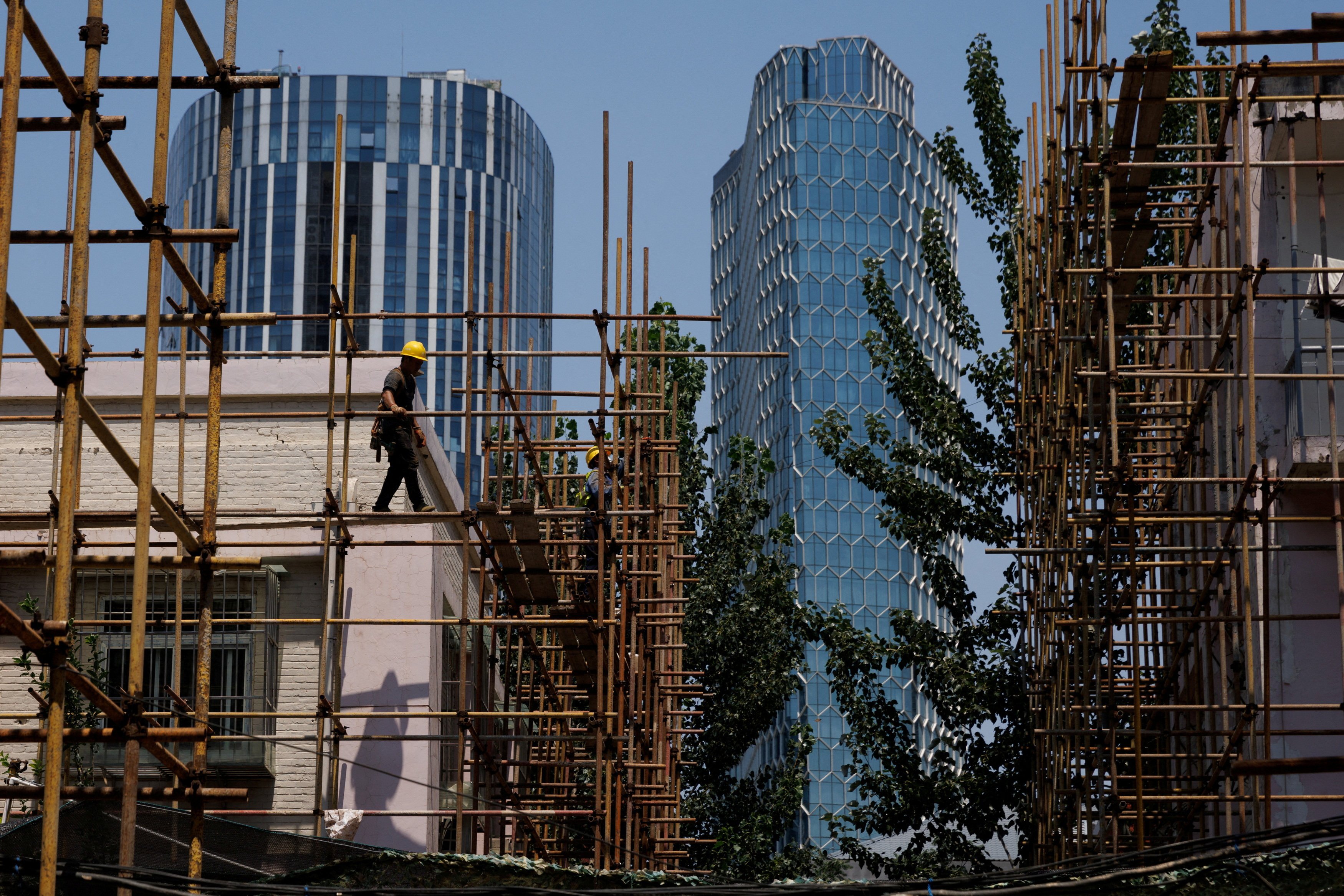 A worker walks on a scaffolding at a construction site of an apartment building under refurbishment in Beijing. Photo: Reuters