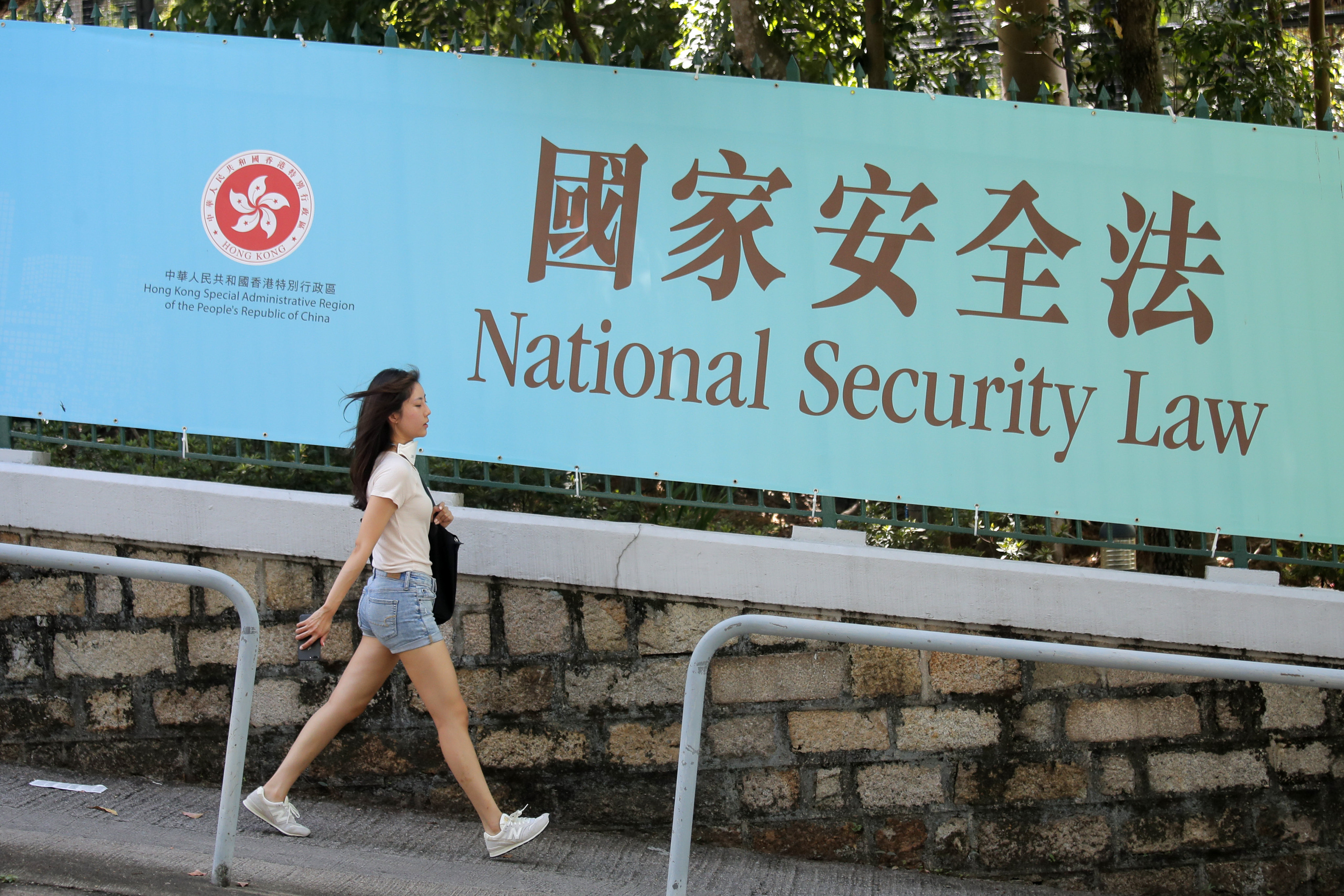 A woman walks past a promotional banner of the national security law for Hong Kong on June 30, 2020. Photo: AP