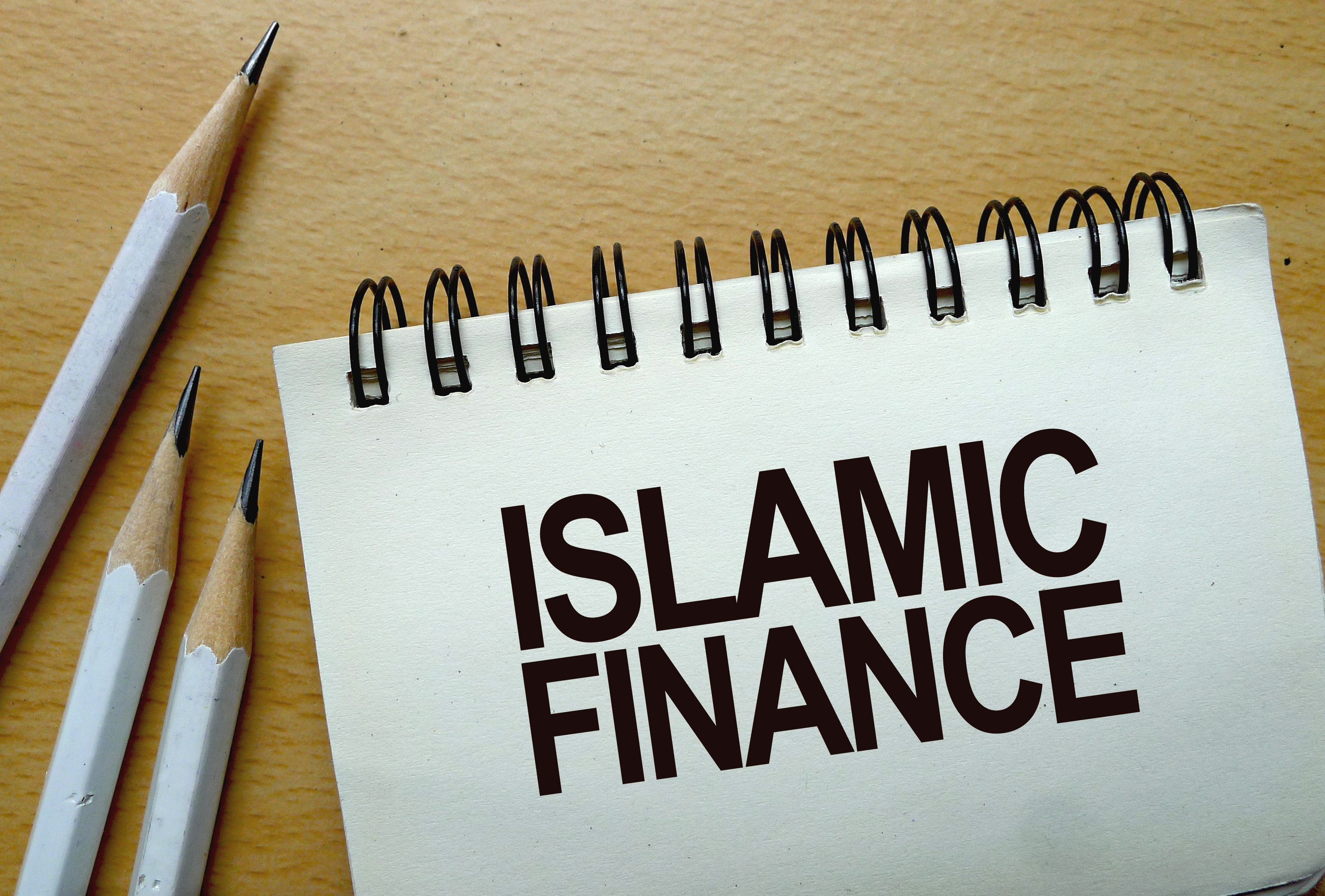 Islamic finance text written on a notebook with pencils. Photo: Shutterstock