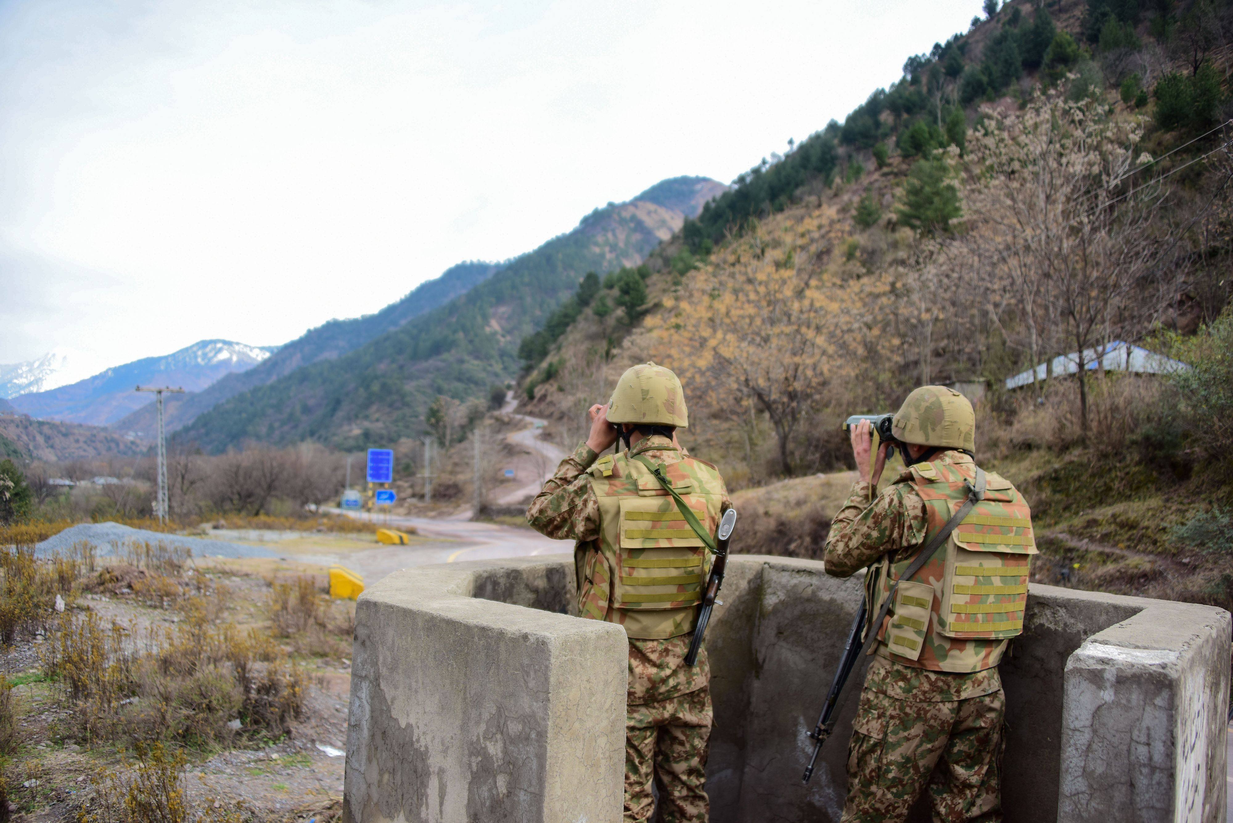 Pakistani soldiers watch over potential Indian troop movements with binoculars in a bunker at the Chakothi post near the border between the two countries. Photo: AFP