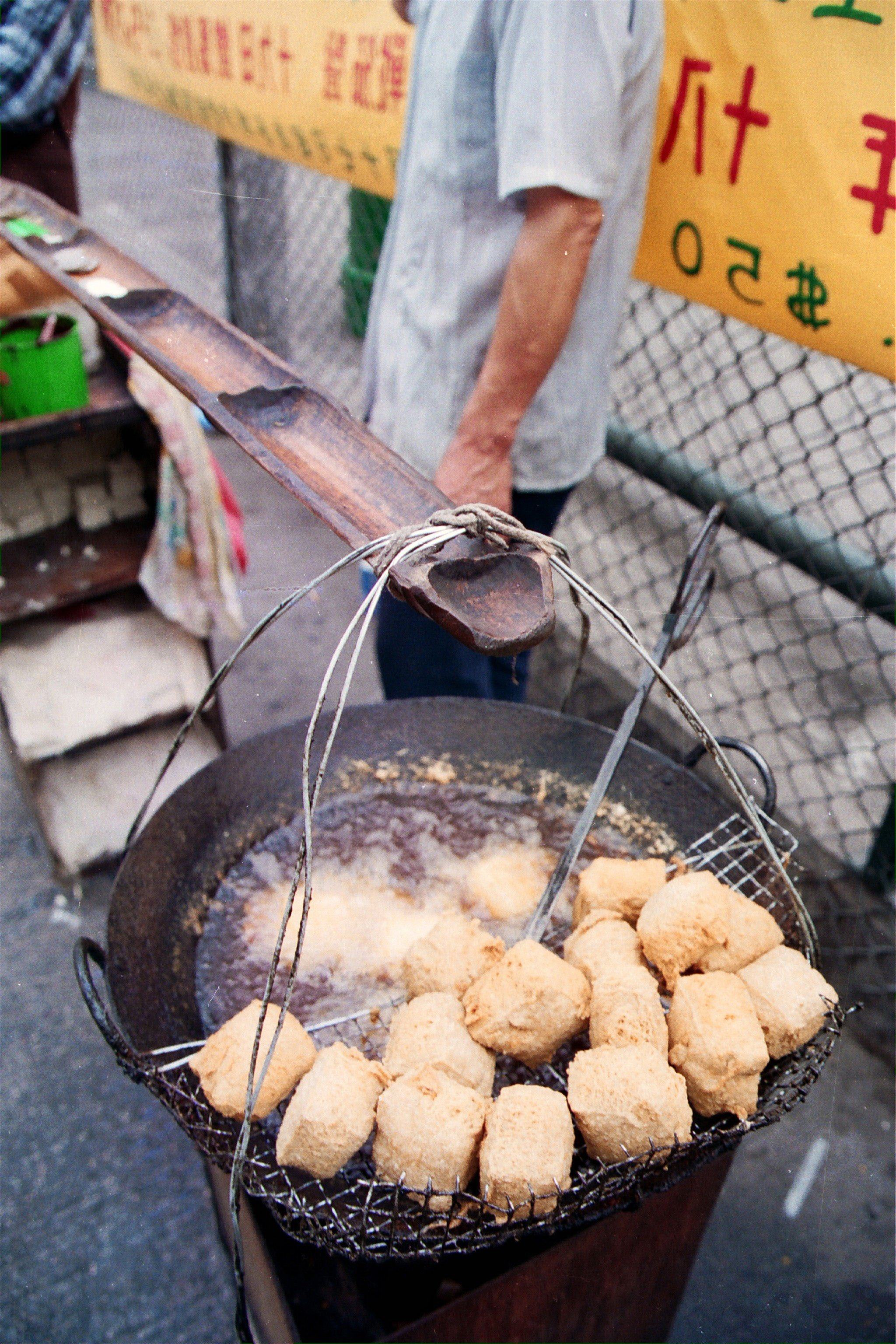 Blocks of fermented bean curd are deep-fried to make 
stinky tofu at a streetside snack stall in Hong Kong. Fermented tofu is a staple of cuisines across China and the diaspora. Photo: SCMP