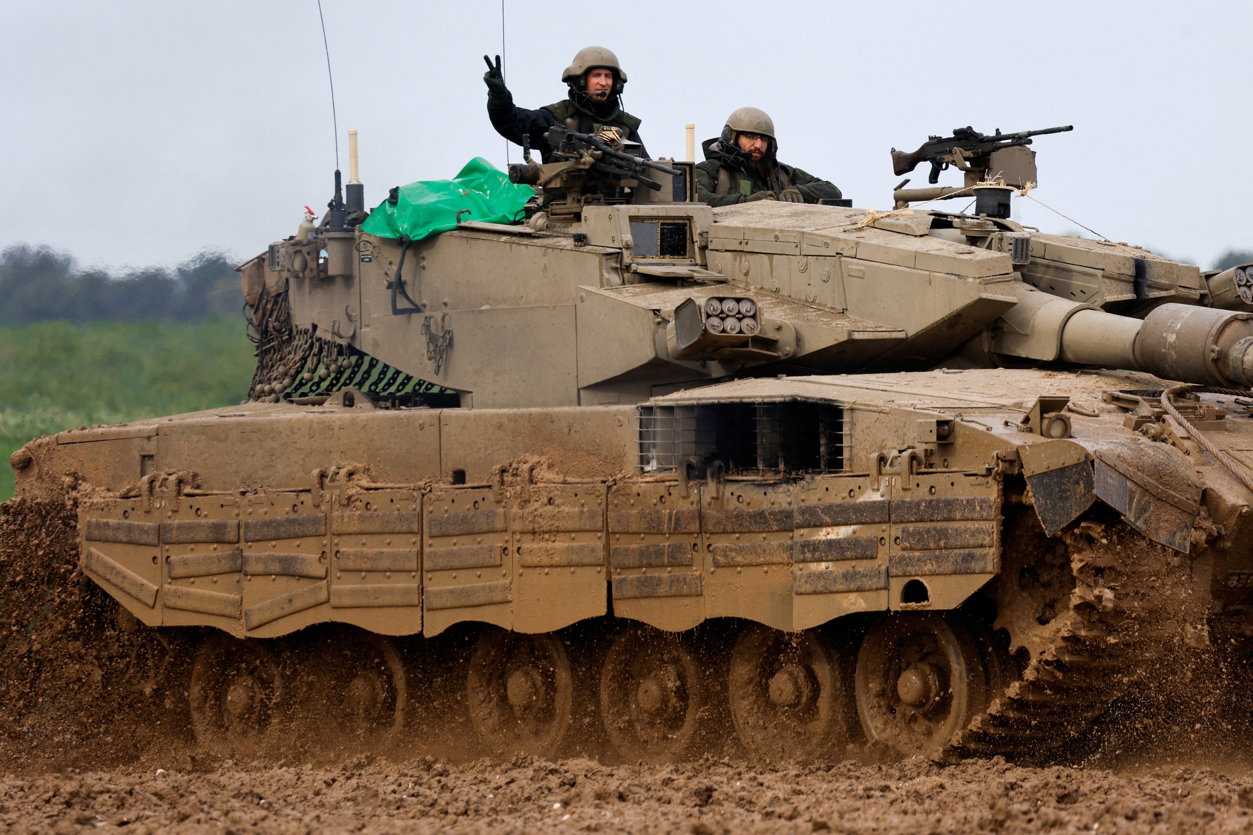 An Israeli soldier gestures to the camera as he rides in a tank near the Israel-Gaza border on Saturday. Photo: Reuters