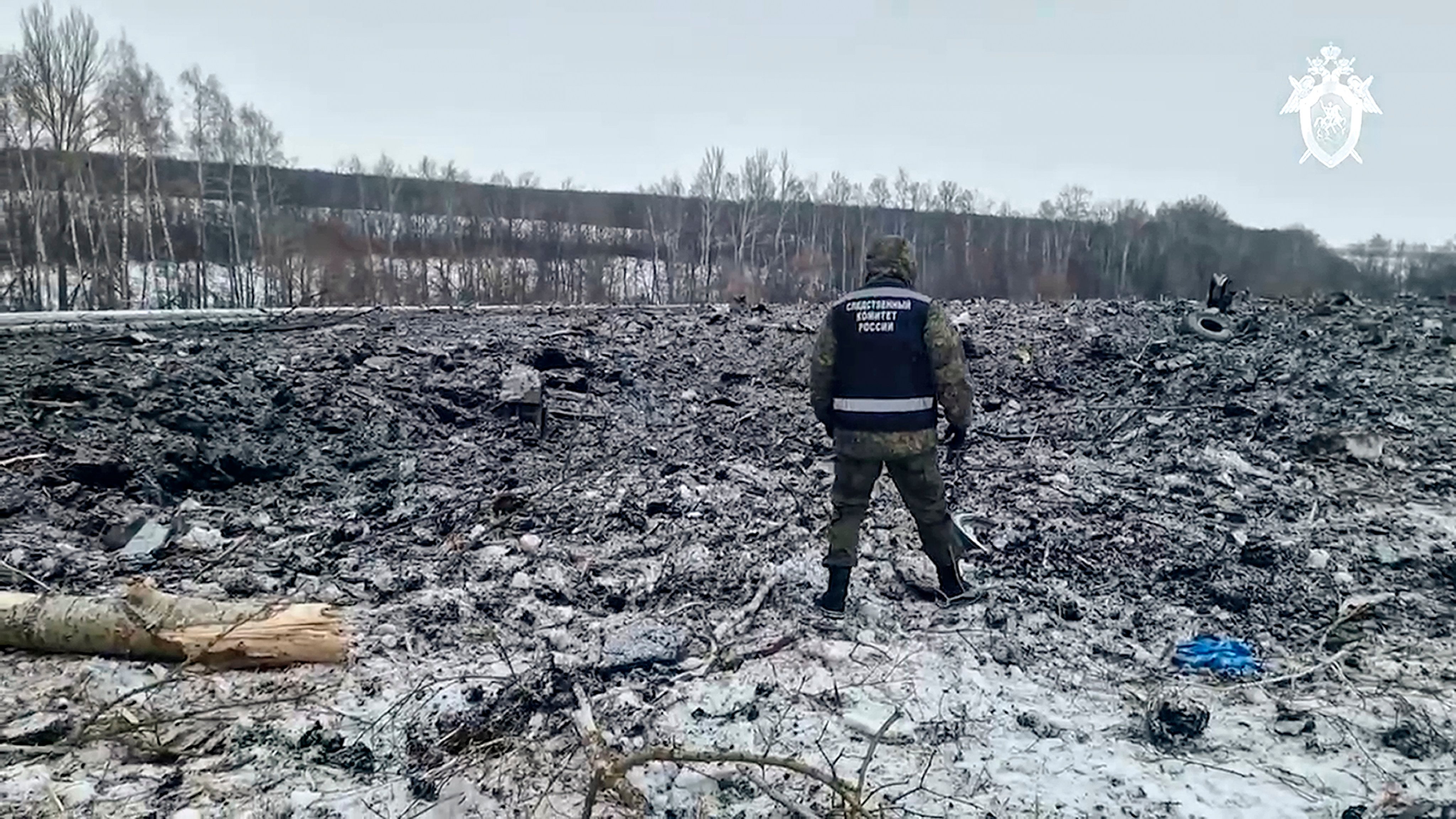 A Russian Investigative Committee employee walks by the wreckage of the Il-76 near Yablonovo, in the Belgorod region of Russia on Thursday. Photo: Russian Investigative Committee via AP