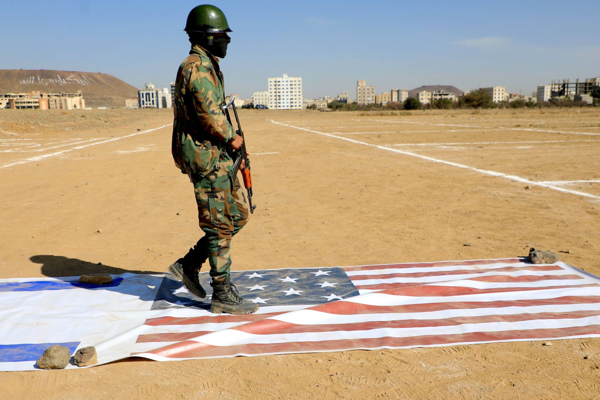 A Yemeni Houthi fighter walks on the flags of Israel and the US during a rally the Iran-backed group held in Sanaa in solidarity with the Palestinian Hamas movement’s armed resistance against Israel on Monday. Photo: AFP
