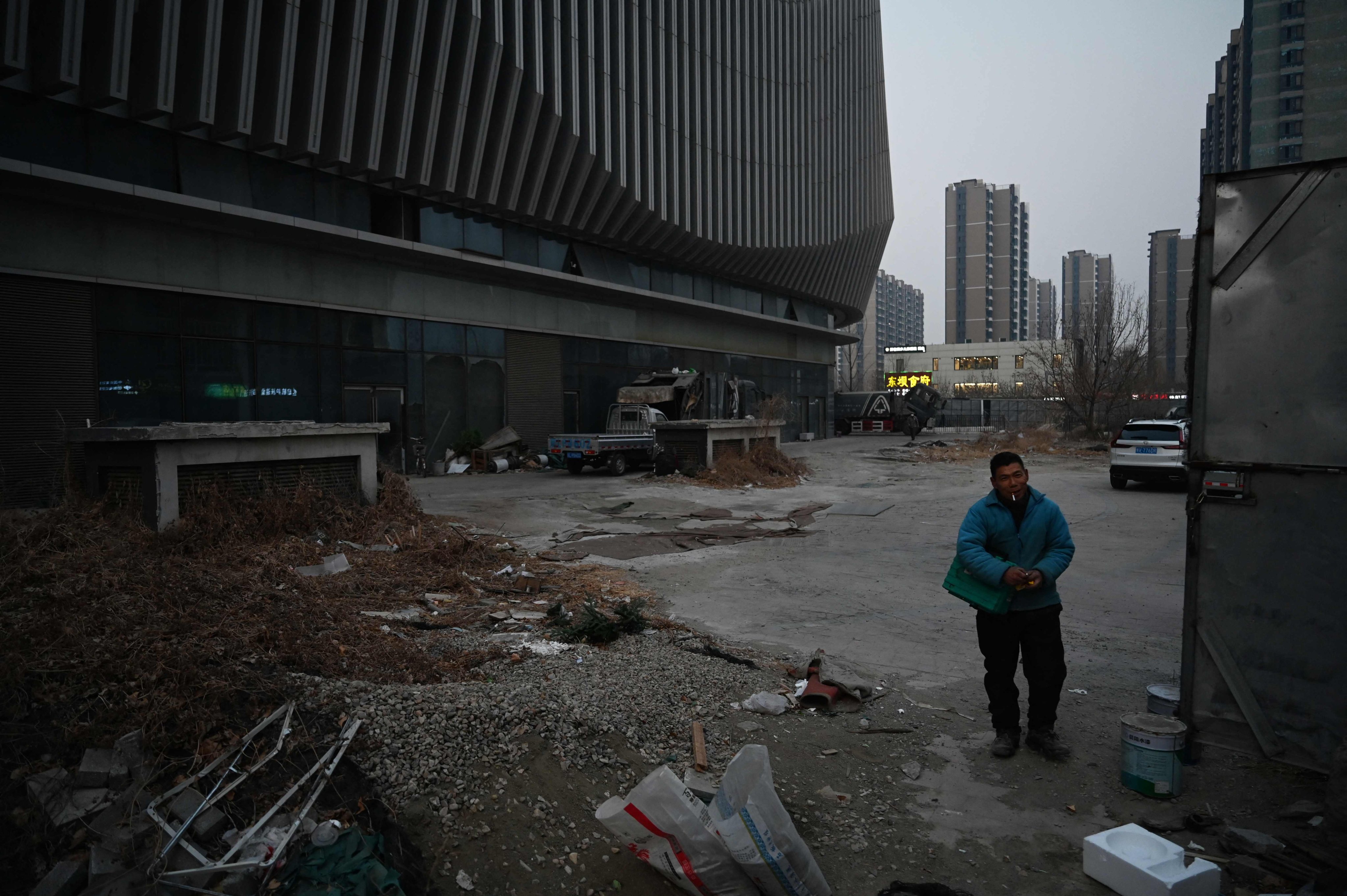 A worker stands outside an abandoned Evergrande commercial complex in Beijing in January 29. Photo: AFP