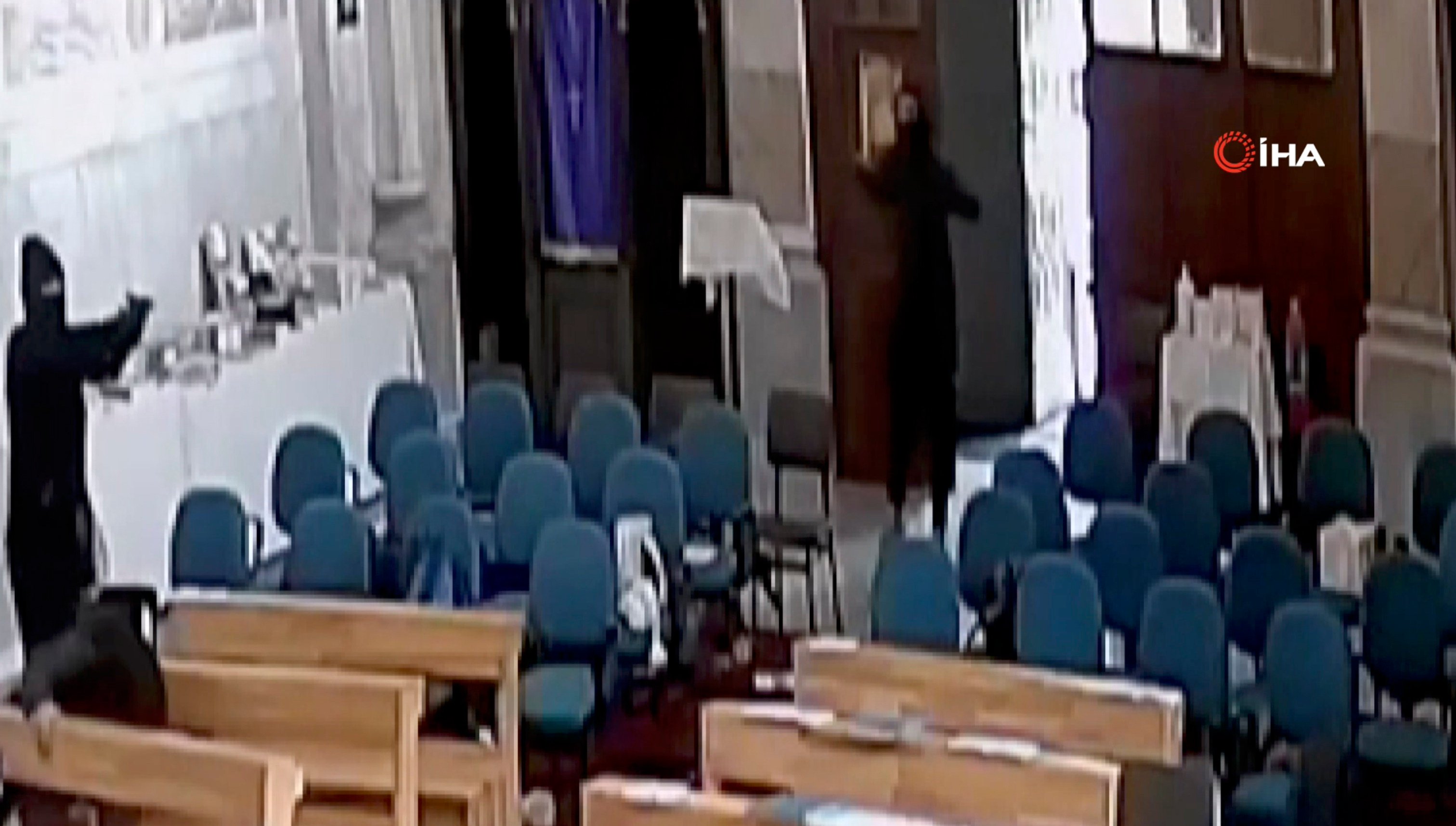 A screenshoot from video footage taken from a CCTV camera shows two masked men holding guns inside Santa Maria church in Istanbul, Turkey on Sunday. Photo: IHA via AP