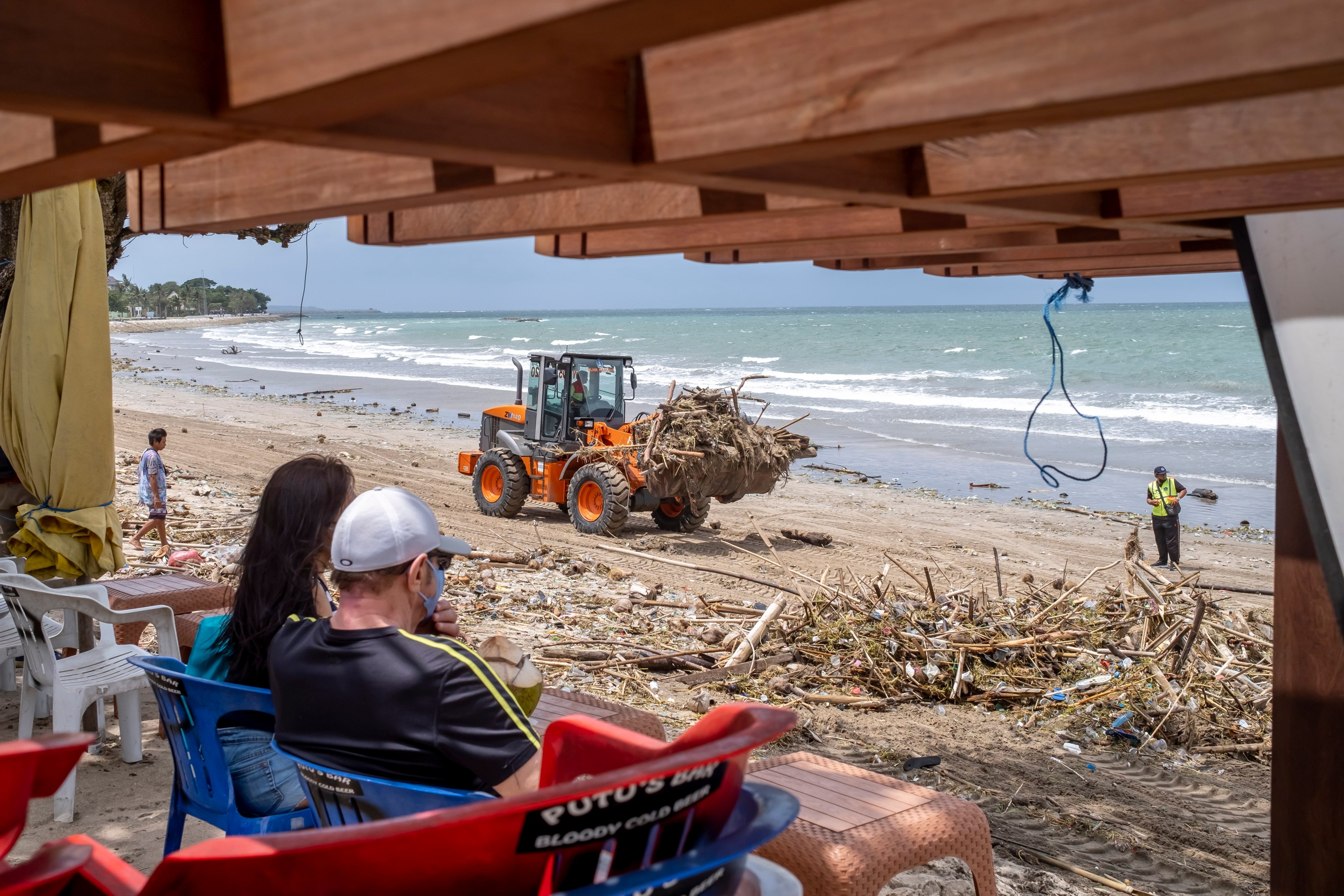 Workers clean debris and plastic waste in Kuta. More than four million intentional holidaymakers visited the island in the first 10 months of 2023. Photo: EPA-EFE