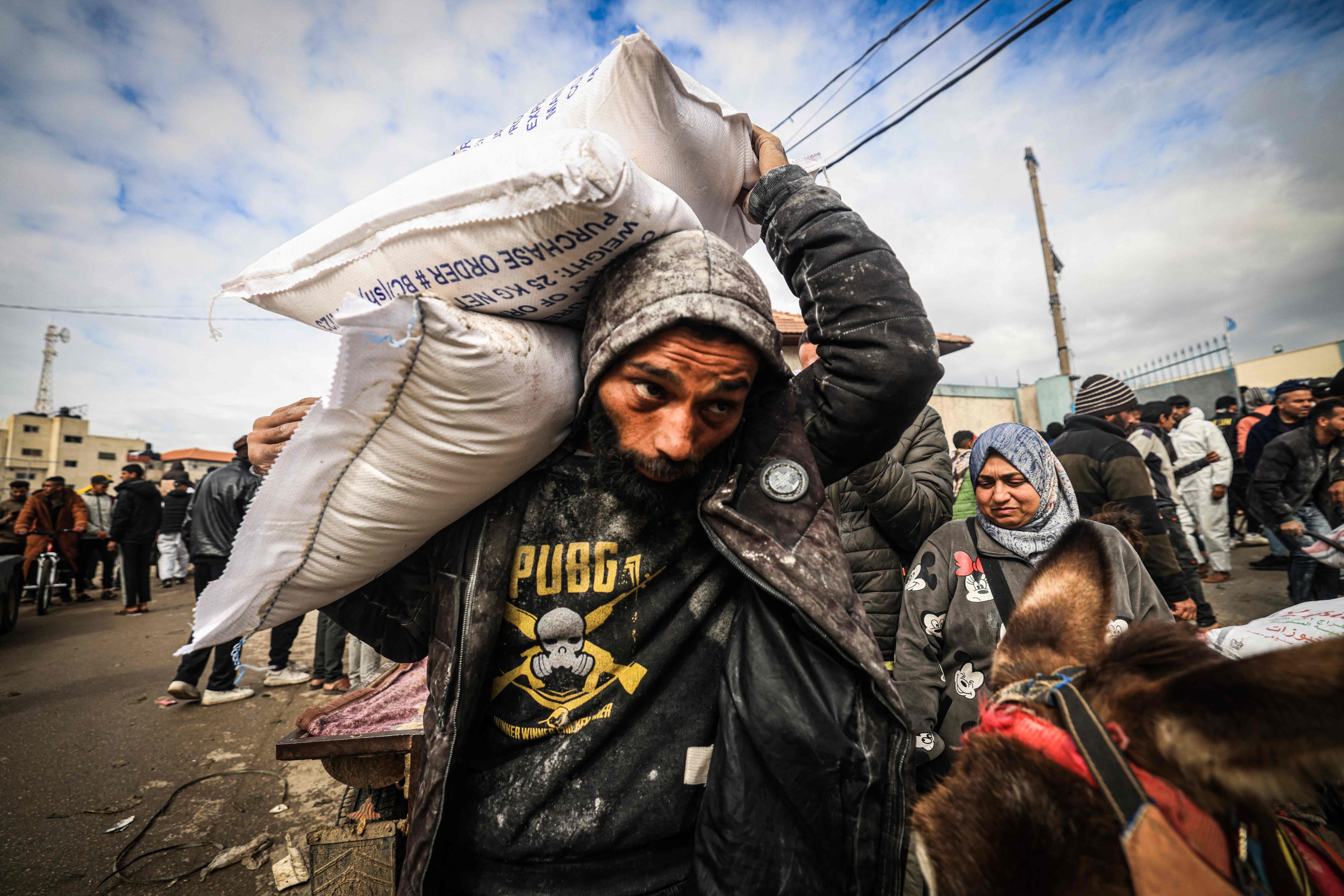 Displaced Palestinians receive food aid at the United Nations Relief and Works Agency for Palestine Refugees (UNRWA) center in Rafah. Photo: AFP