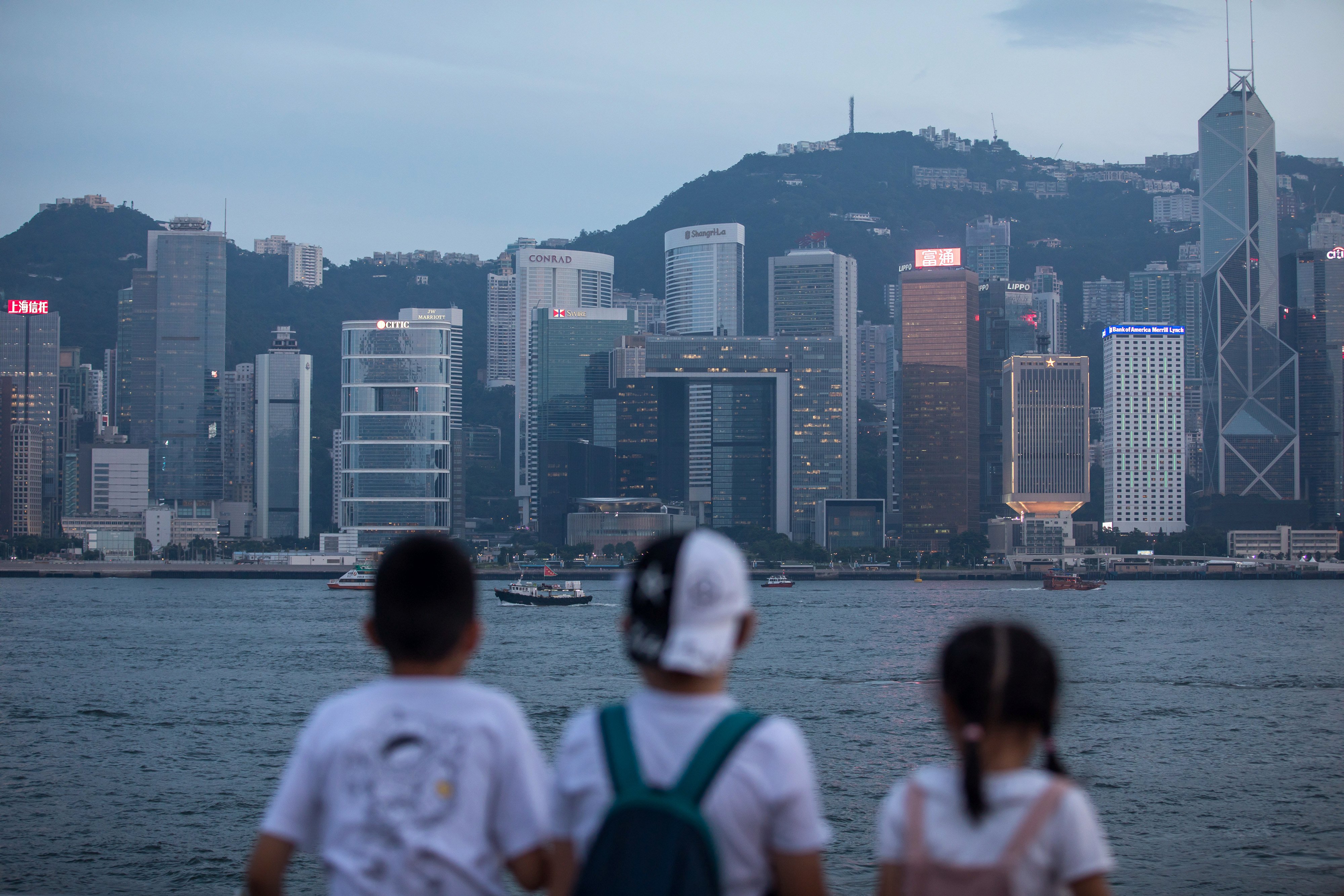 Children look at the Hong Kong Island skyline from Tsim Sha Tsui in 2019. While the Hong Kong government’s green bonds are aimed at promoting the development of related markets, there are concerns about the need for continuous issuance over a decade. Photo: Bloomberg