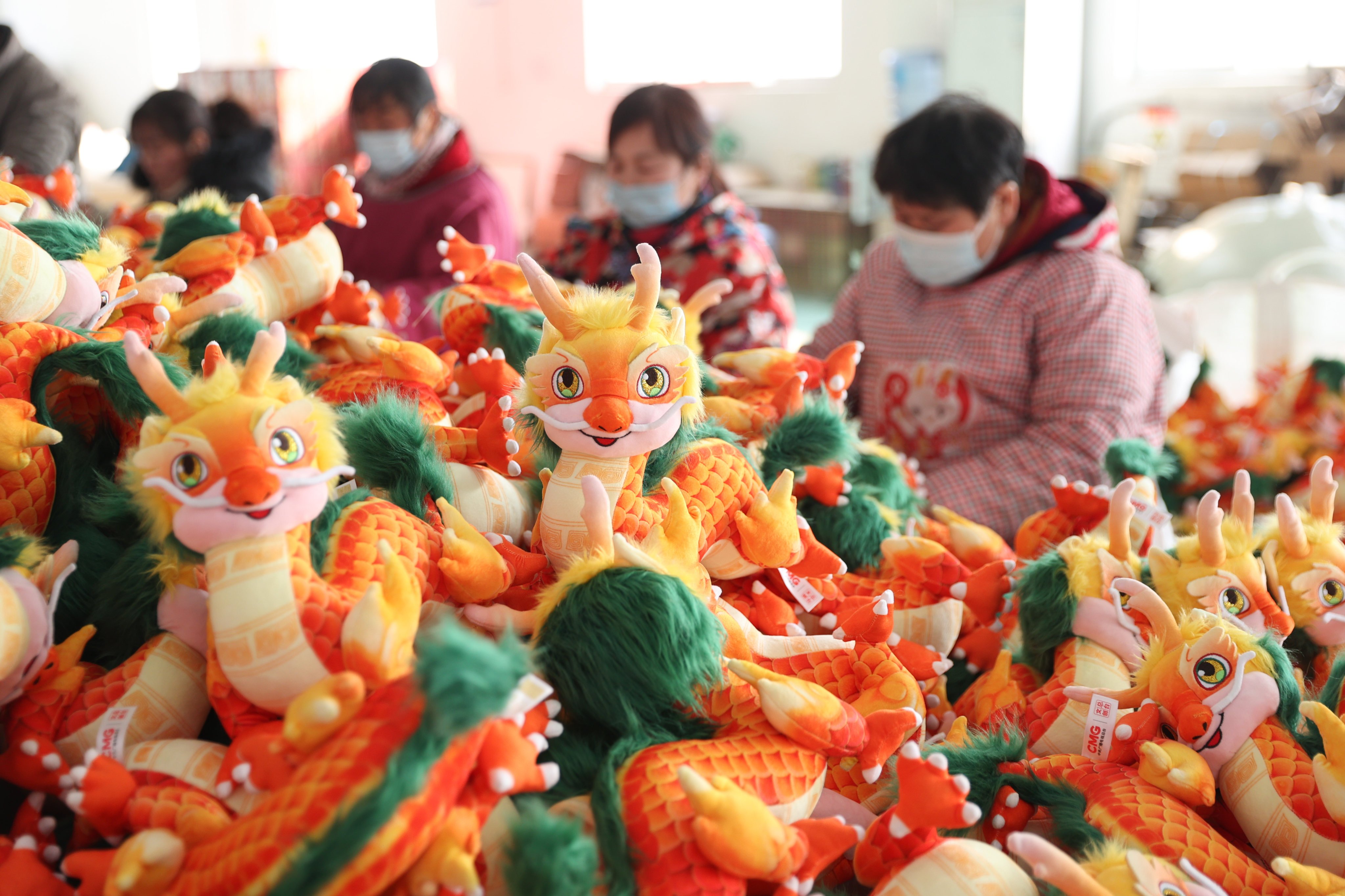 Workers produce dragon toys ahead of the start of the Year of the Dragon at a toy company in Chengtou town in eastern China’s Jiangsu province on January 27. Photo: Getty Images