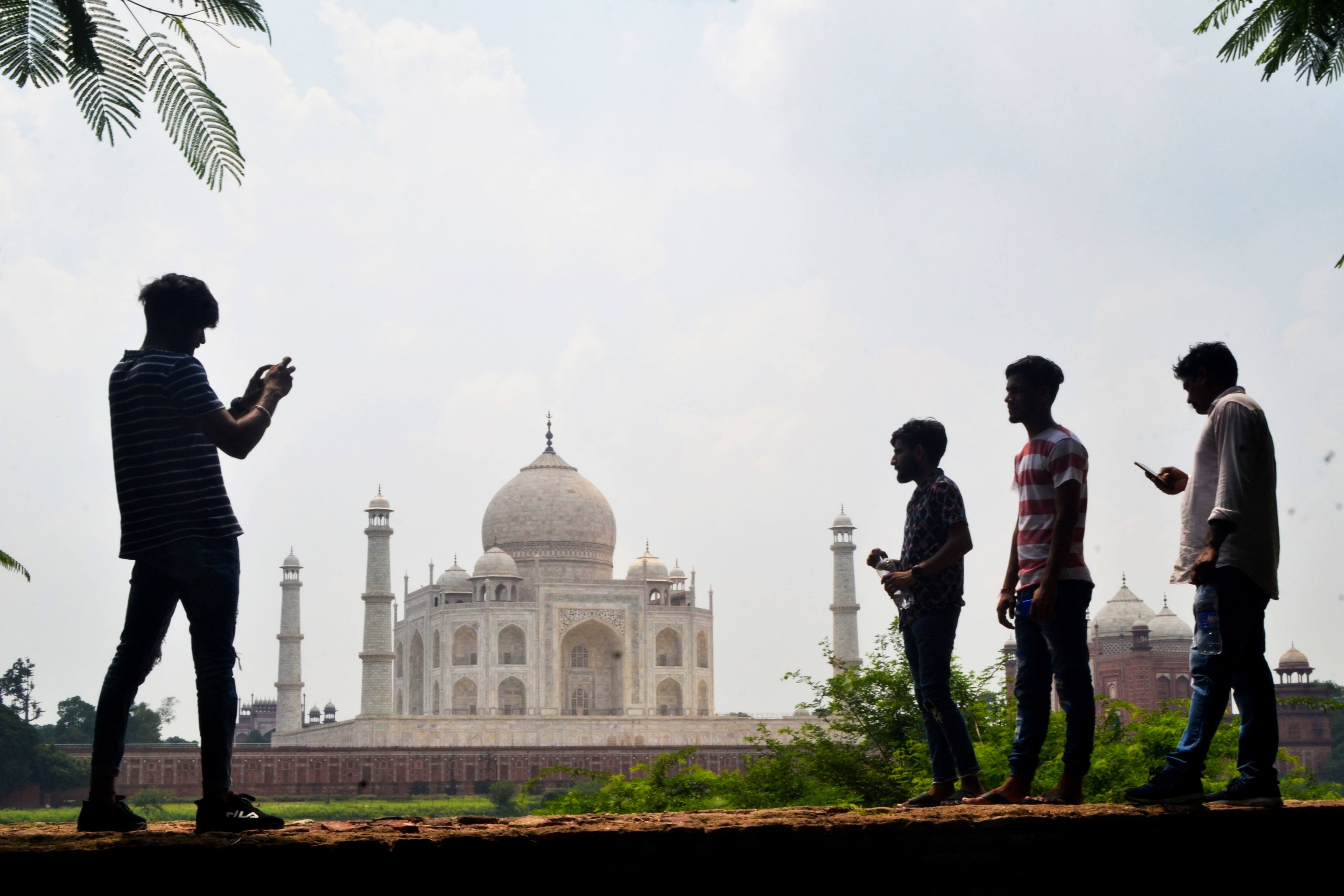 Young people take pictures with their mobile phones in Agra. Photo: AFP 