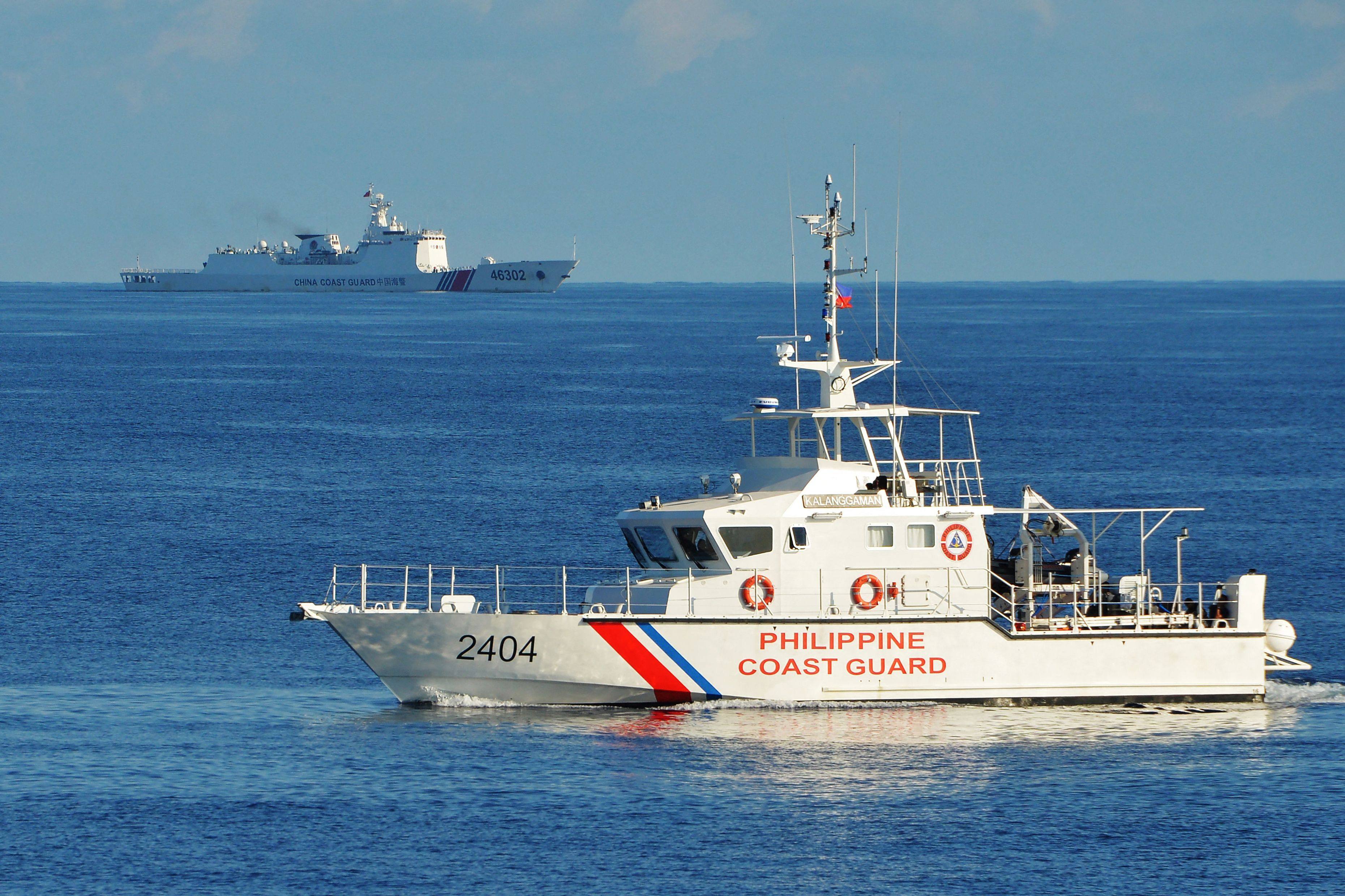 A Philippine coast guard ship (right) sails past a Chinese coast guard vessel on May 14, 2019, near the Scarborough Shoal in the South China Sea. Photo: AFP