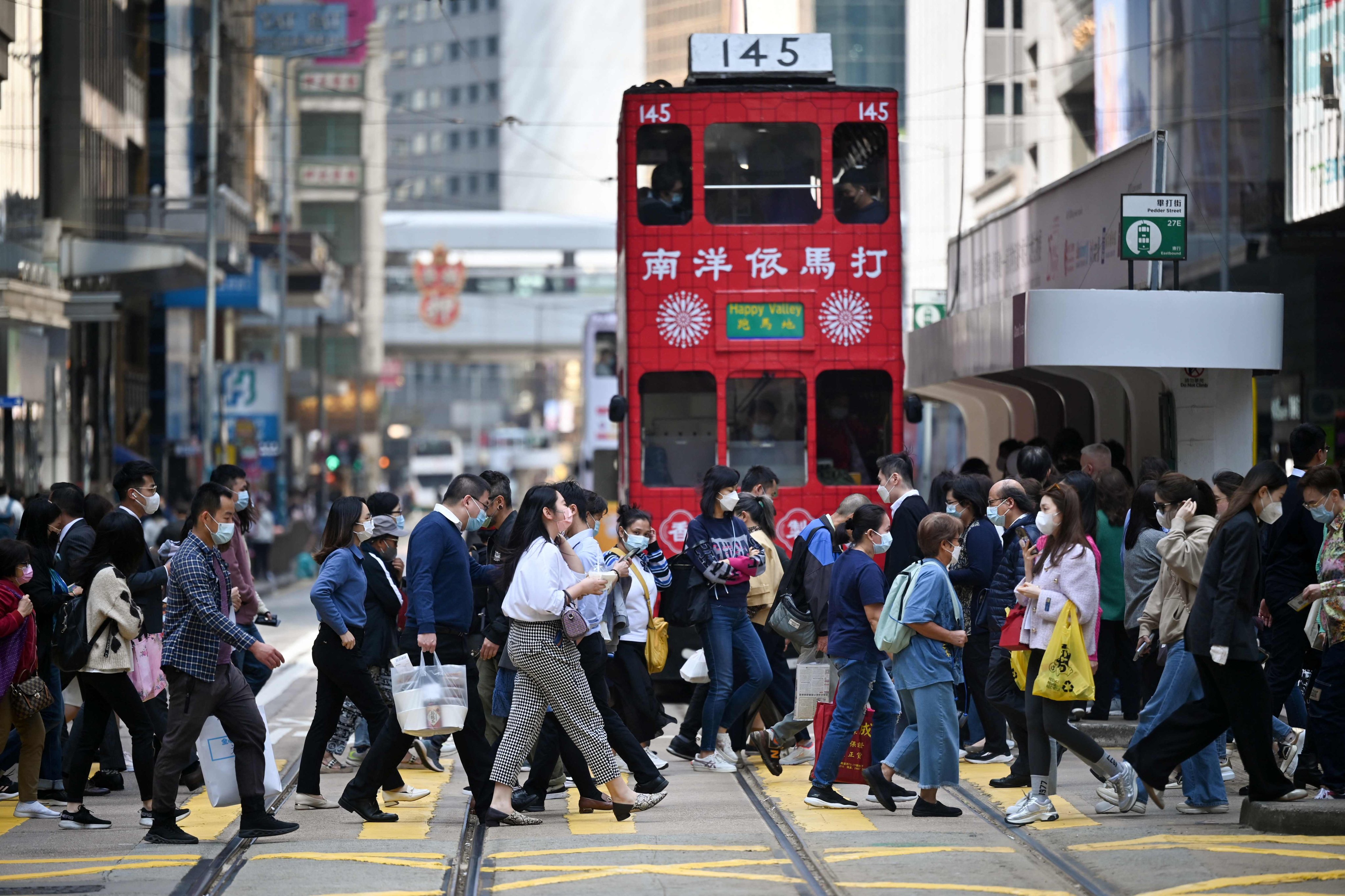 Pedestrians crossing a street in Central district of Hong Kong on February 23, 2023. Photo: AFP