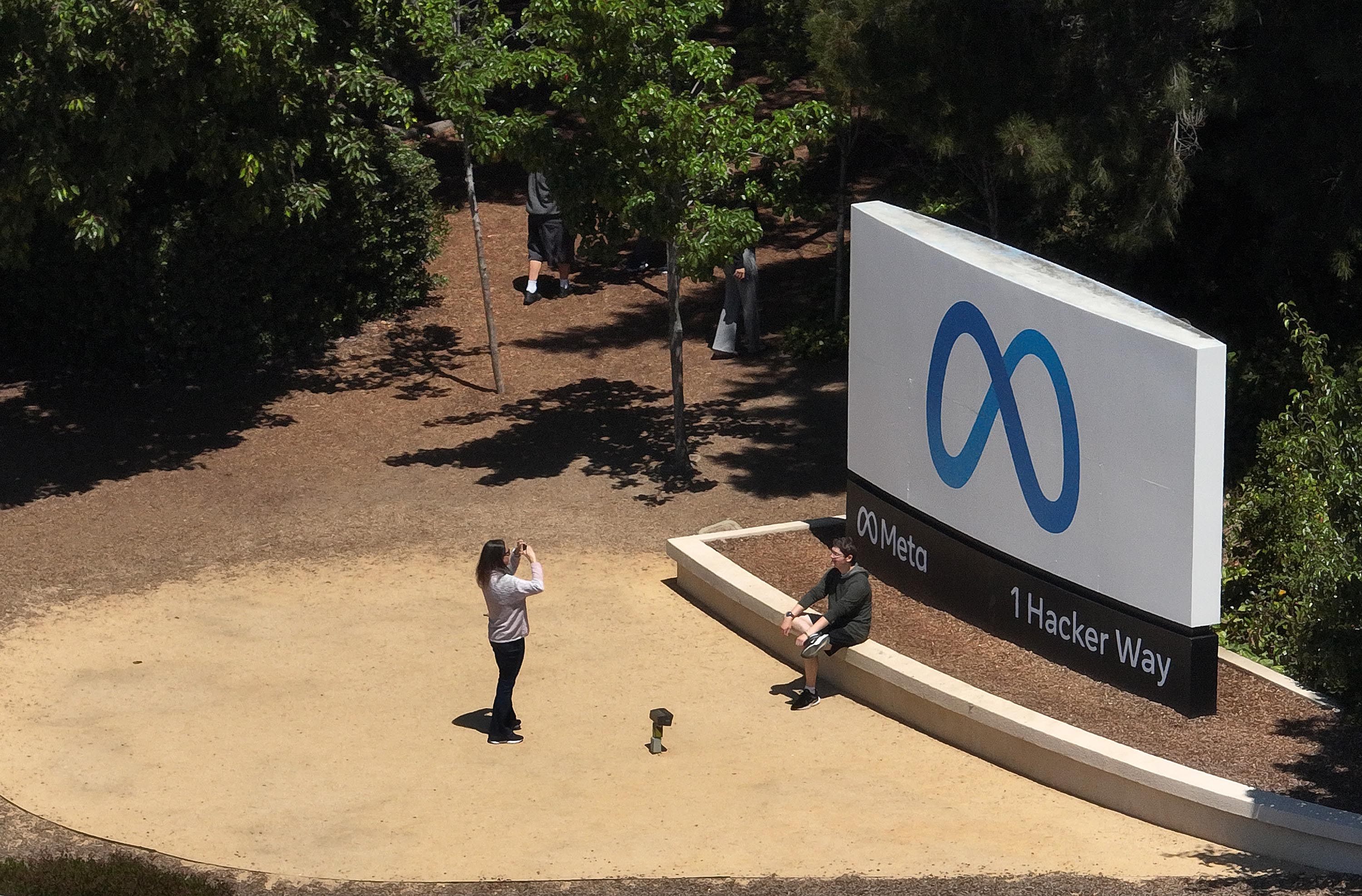 In an aerial view, people take pictures in front of a sign at Meta Platforms' headquarters in Menlo Park, California, on July 7, 2023. Photo: Getty Images/TNS