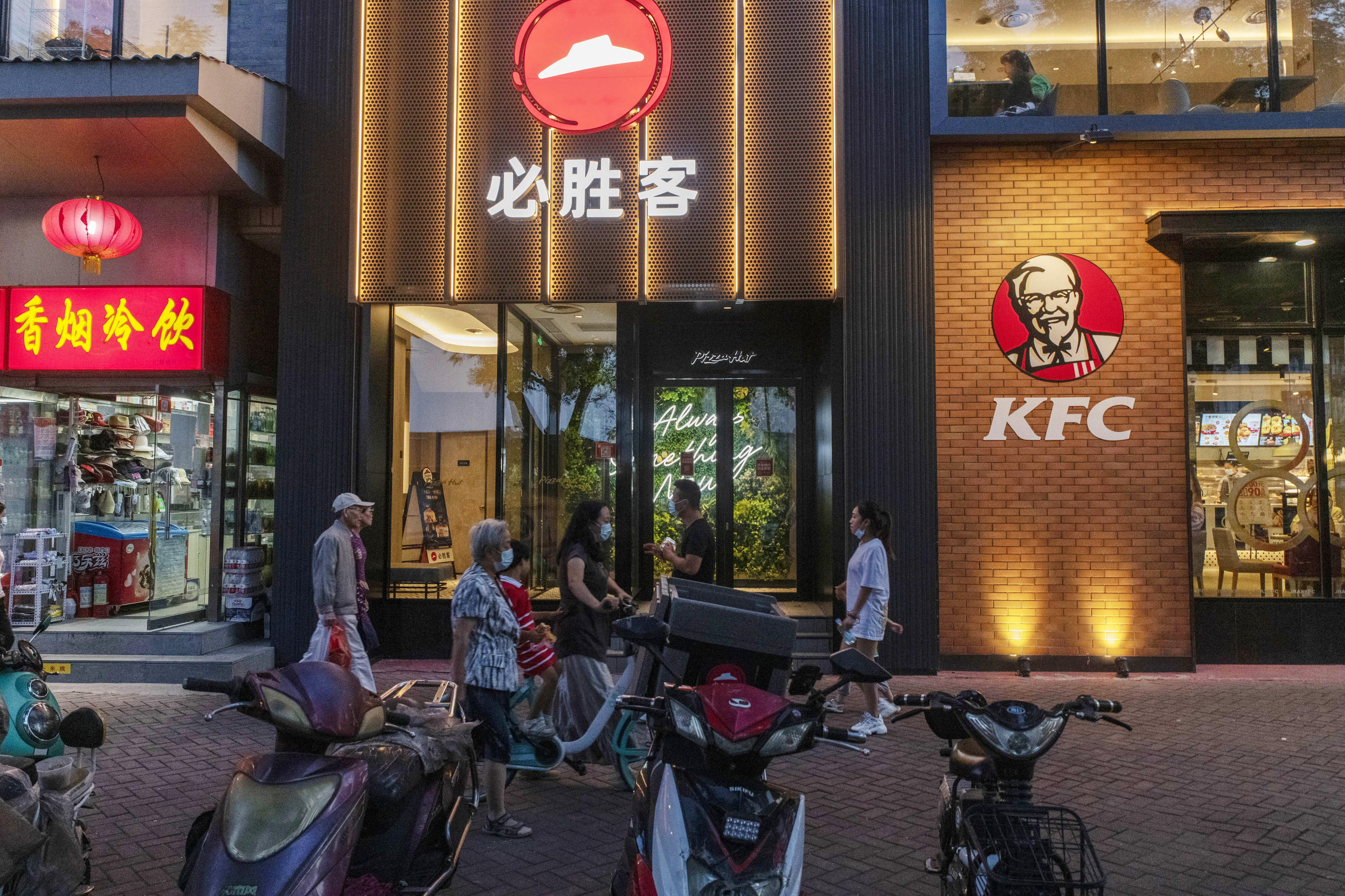 Pedestrians walk past a Pizza Hut restaurant and a KFC restaurant, both operated by Yum China, in Beijing n September 2020. Photo: Bloomberg