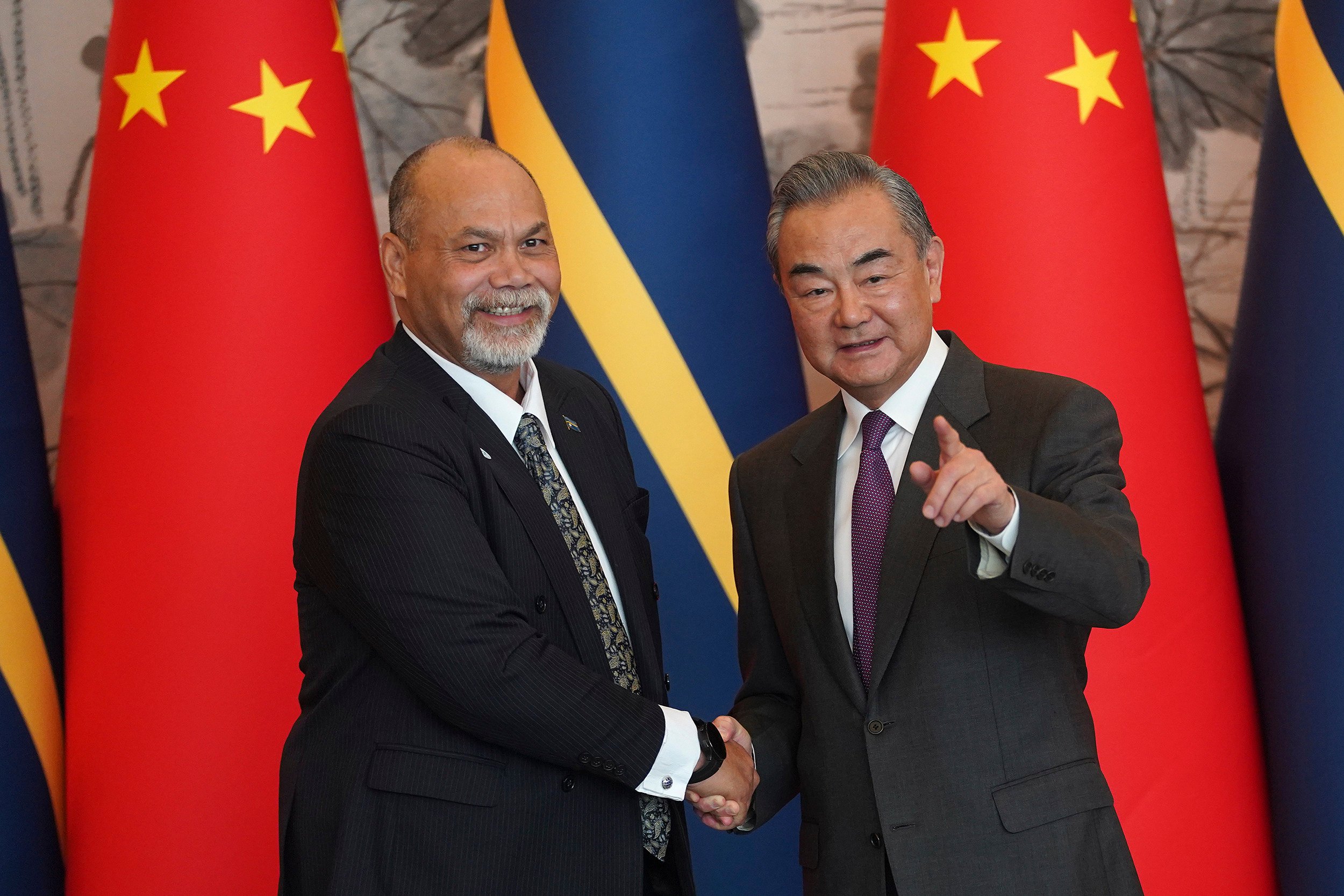 Chinese Foreign Minister Wang Yi, right, and Nauru’s Minister of Foreign Affairs and Trade Lionel Aingimea shake hands after signing a joint communique on the resumption of diplomatic relations between China and Nauru at Diaoyutai State Guesthouse in Beijing last month. Photo: AP