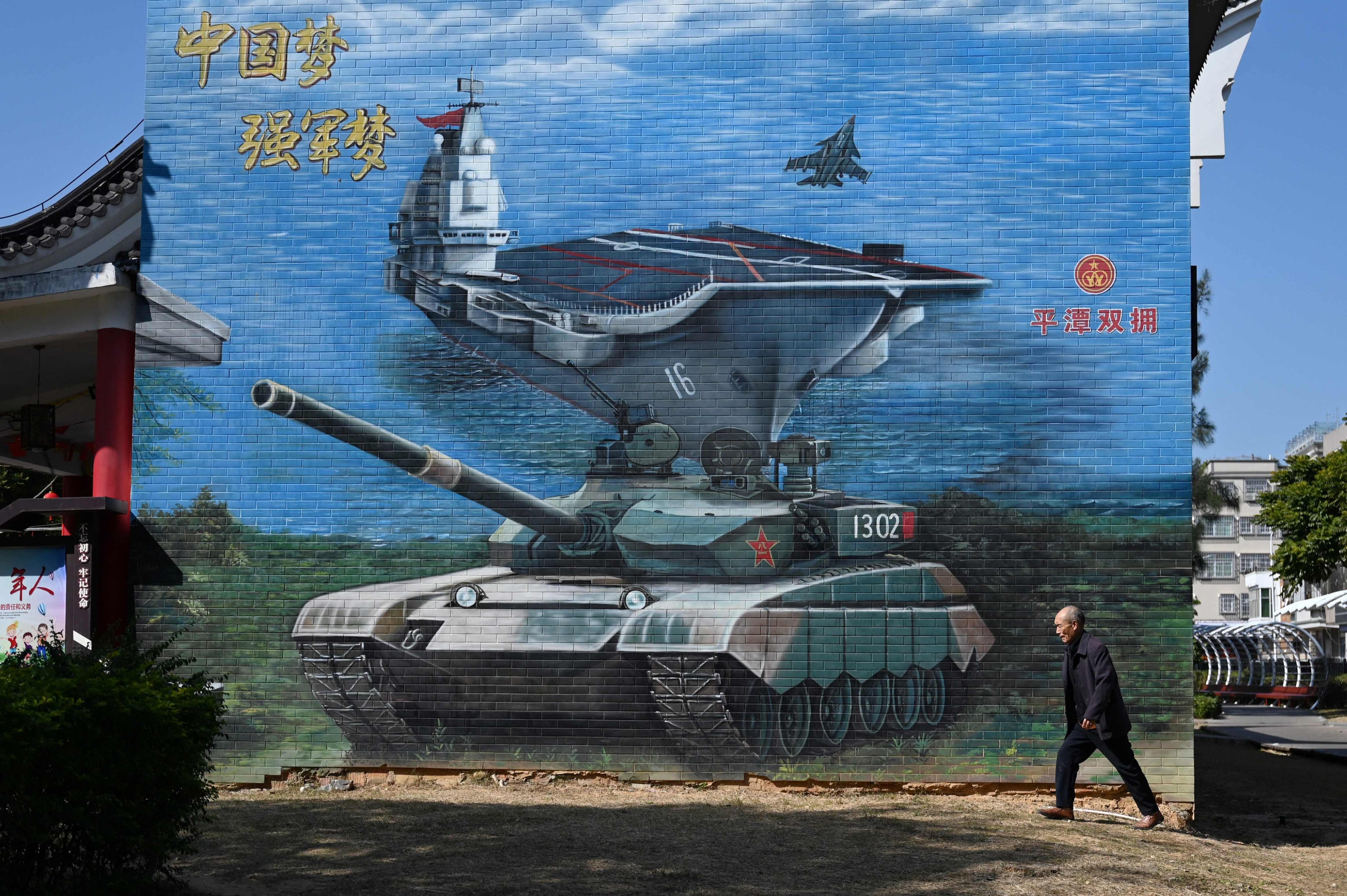 A man walks past a military-themed mural on Pingtan Island in Fujian province, the closest point in mainland China to Taiwan, on January 14. Photo: AFP