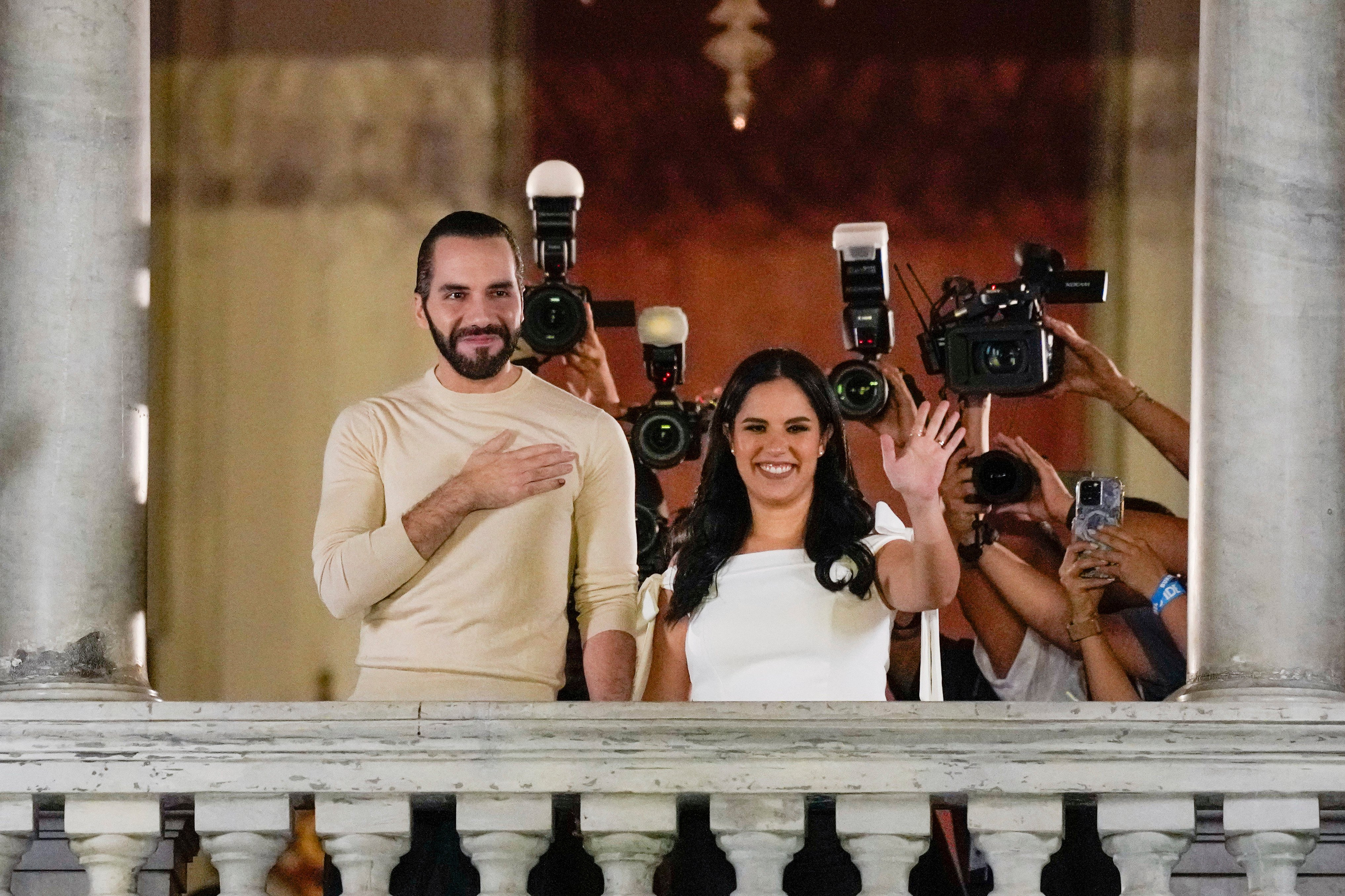 El Salvador President Nayib Bukele and his wife Gabriela Rodriguez wave to supporters from the balcony of the presidential palace in San Salvador. Photo: AP