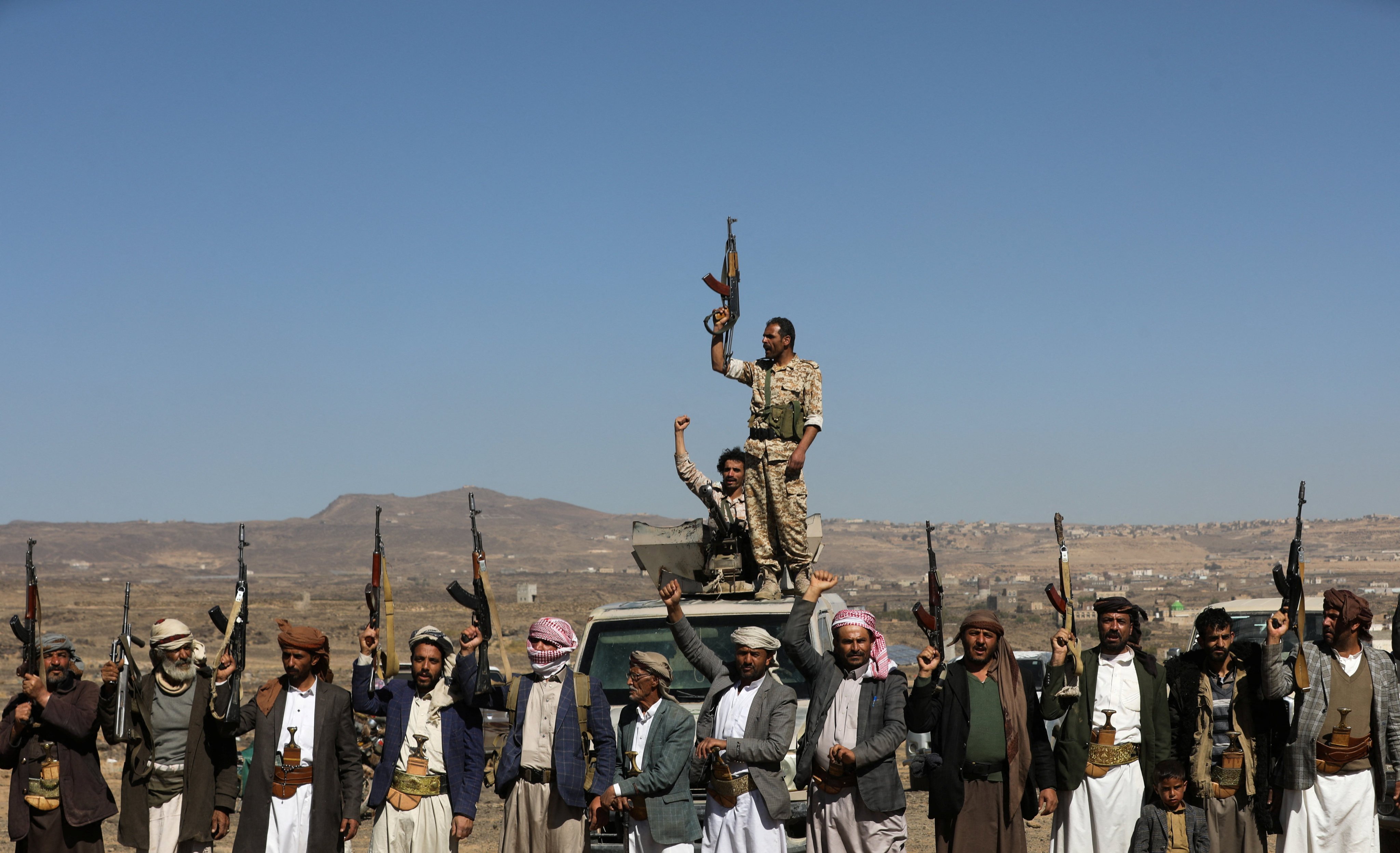 Houthi fighters and tribal supporters hold up their firearms during a protest against recent U.S.-led strikes on Houthi targets, near Sanaa, Yemen. Photo: Reuters/File