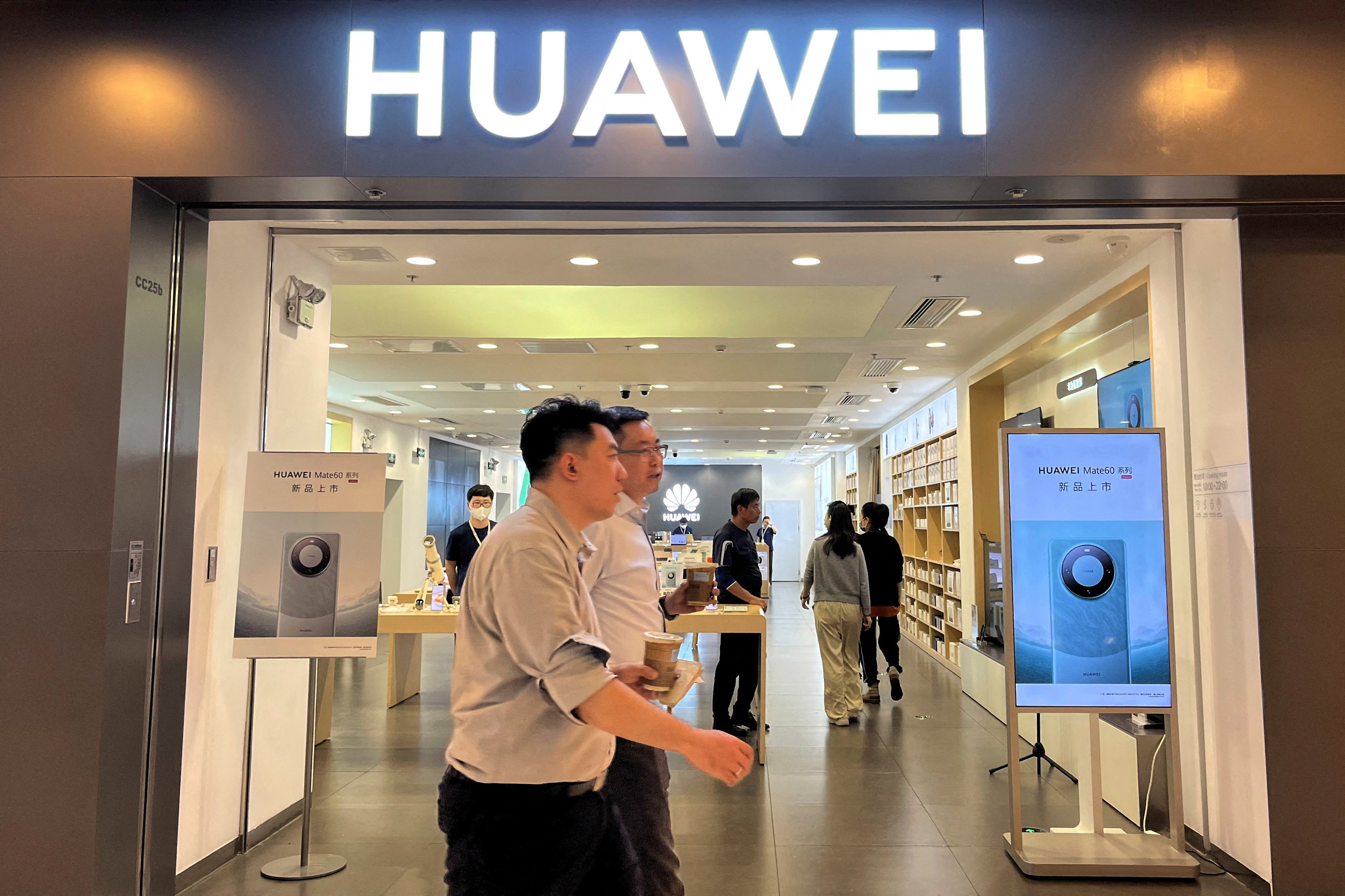 People walk past a Huawei Technologies store, with advertisements for its Mate 60 Pro smartphone, at a shopping centre in Beijing on August 30, 2023. Photo: Reuters