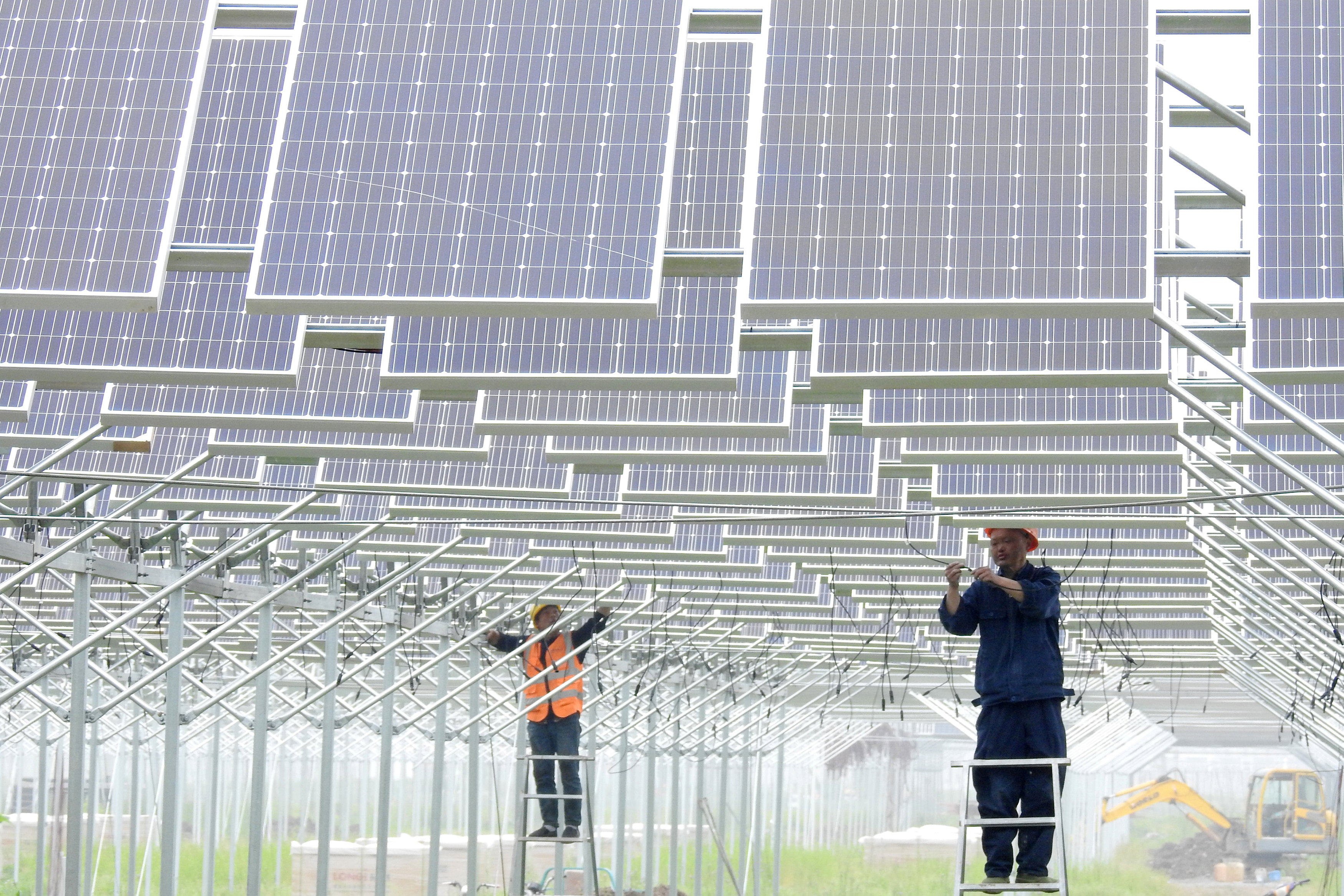Workers install solar panels in Lianyungang, Jiangsu province. Offshore bond issuance from Chinese firms fell last year. Photo: Reuters 