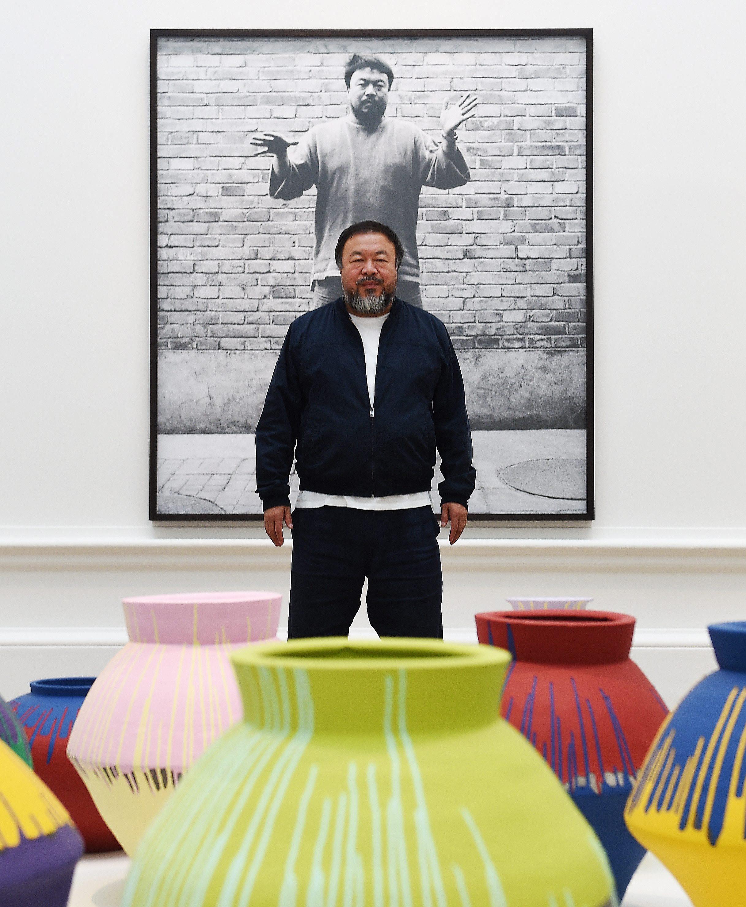 Chinese artist Ai Weiwei stands with his artwork ‘Coloured Vases’ (2015) during the unveiling of his new exhibition at the Royal Academy of Arts in London, United Kingdom on September 15, 2015. Photo: EPA