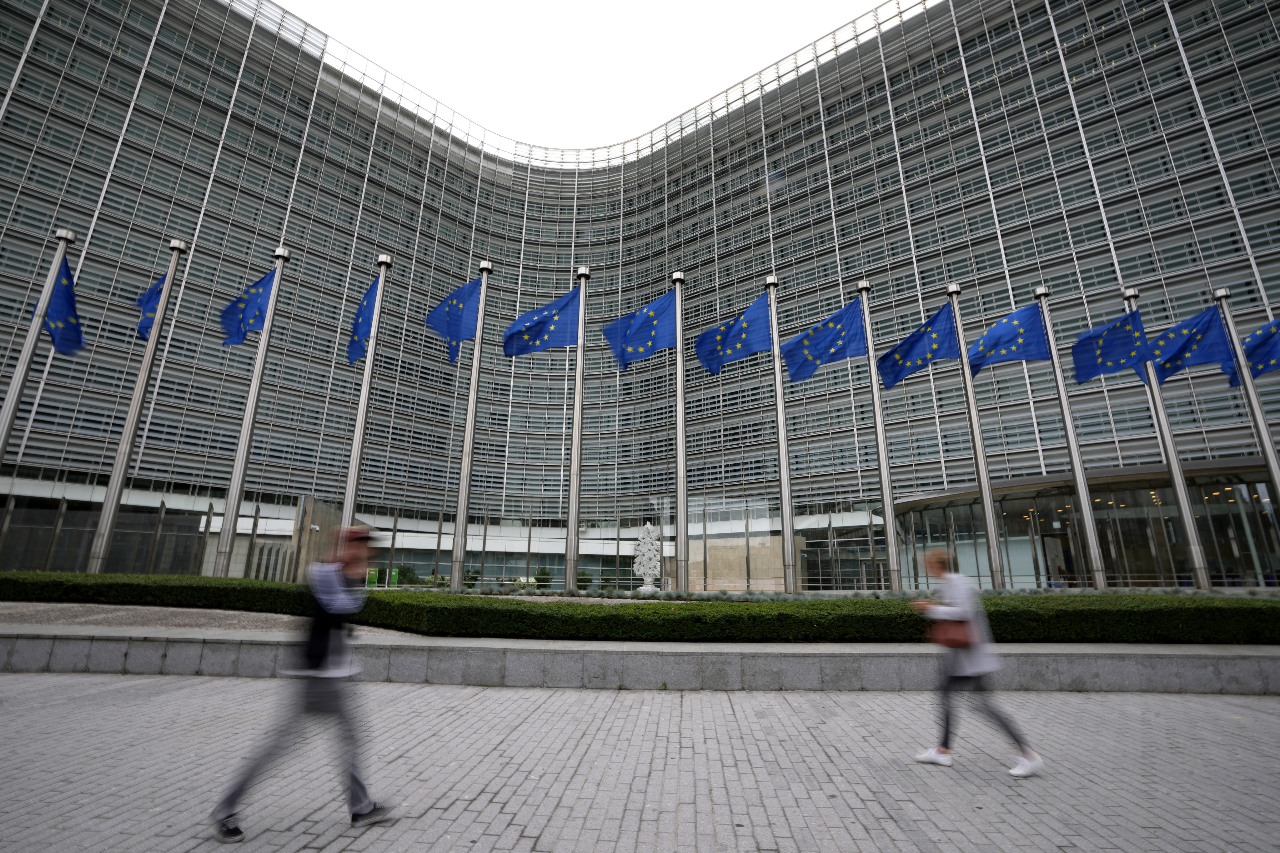 European Union flags flap in the wind as pedestrians walk by EU headquarters in Brussels. The law aims to protect women in the 27-nation European Union from gender-based violence, forced marriages, female genital mutilation and online harassment. Photo: AP