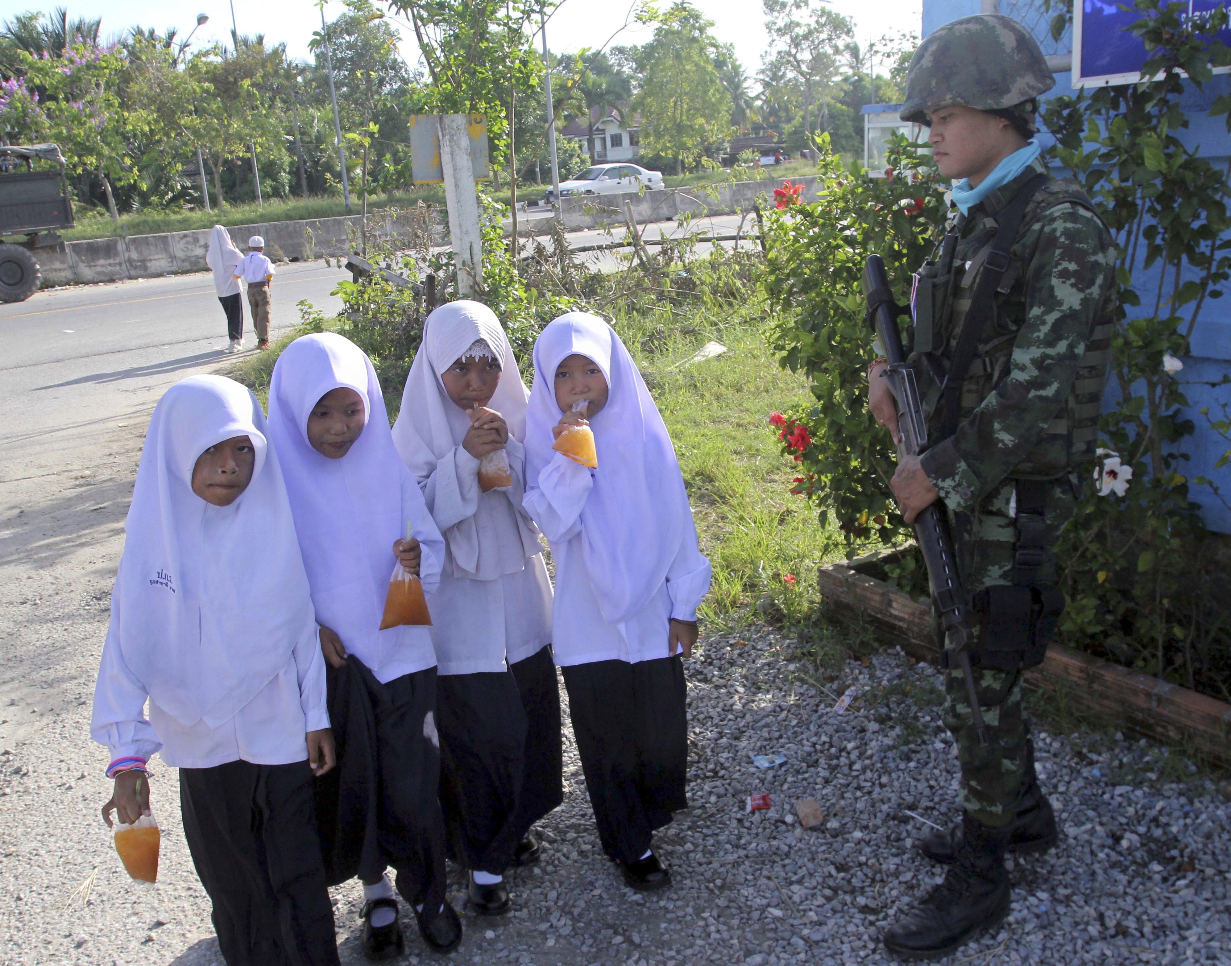 Muslim students walk pass a Thai soldier outside a school in Pattani province, southern Thailand, in 2013. Photo: EPA