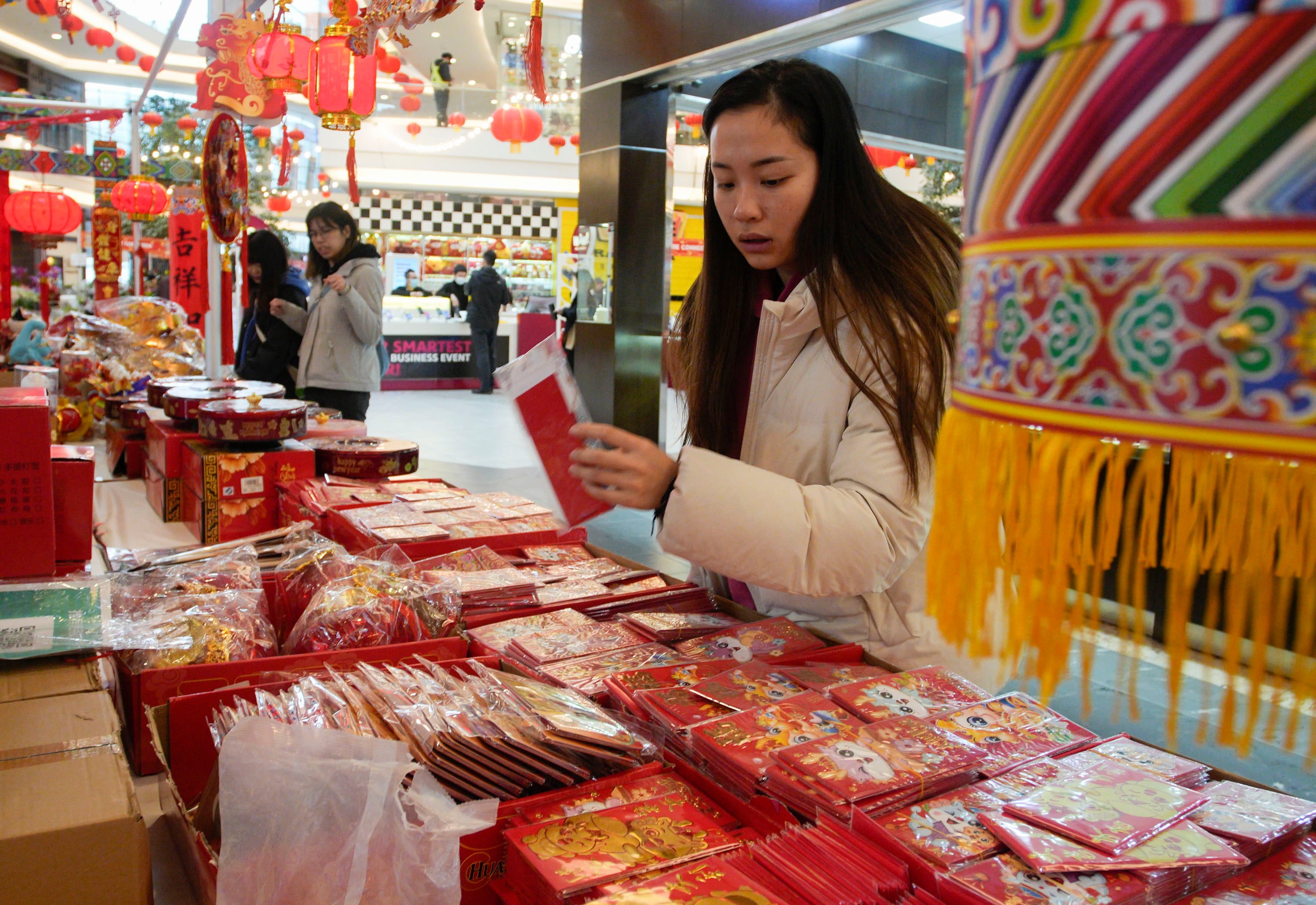 A woman selects red envelopes at the Lunar New Year Flower and Gift Fair in Richmond, British Columbia, on February 2. The tradition of handing out red packets remains strong both in China and among Chinese communities overseas. Photo: Xinhua