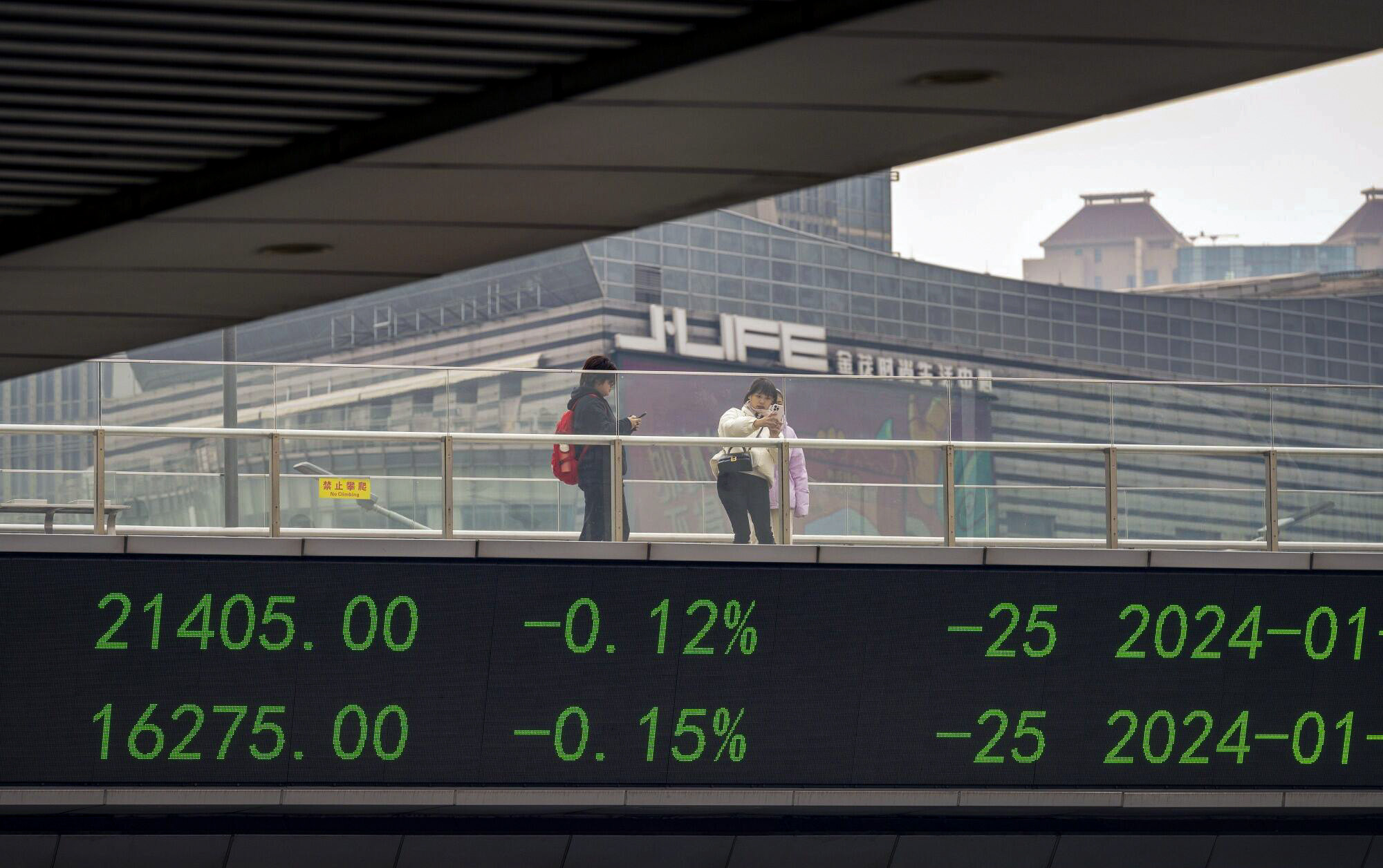 An electronic ticker displays stock figures in Shanghai’s Lujiazui Financial District. China has imposed short selling restrictions in a bid to support the country’s slumping stock markets. Photo: Bloomberg