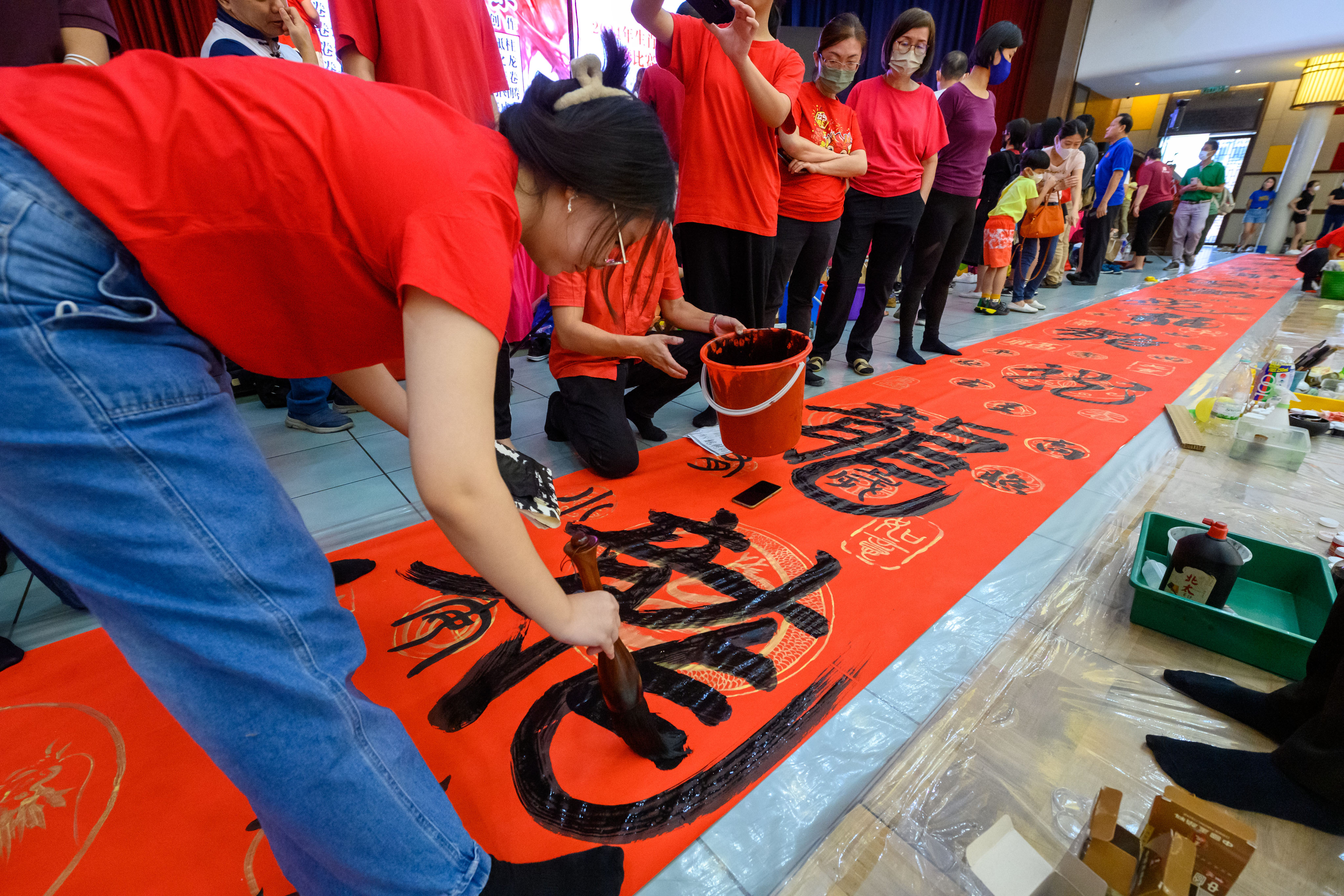 Students create a long scroll in Klang, Selangor state, Malaysia, on January 28 to celebrate the coming Lunar New Year of the Dragon. Photo: Chong Voon Chung/Xinhua