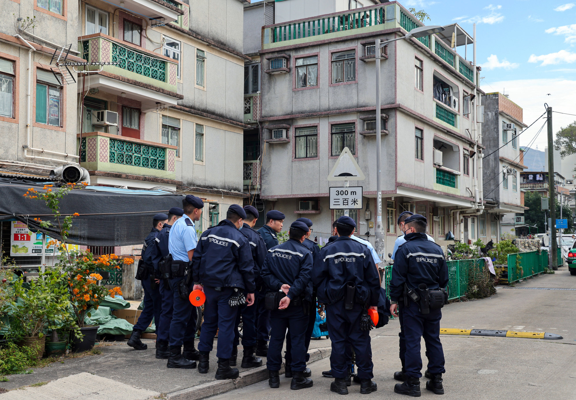 Police officers escort one of the suspects, Kwan Wing-yin, back to an apartment in Fanling Wai, Sheung Shui for a re-enactment of the manslaughter case in December. Photo: Jelly Tse