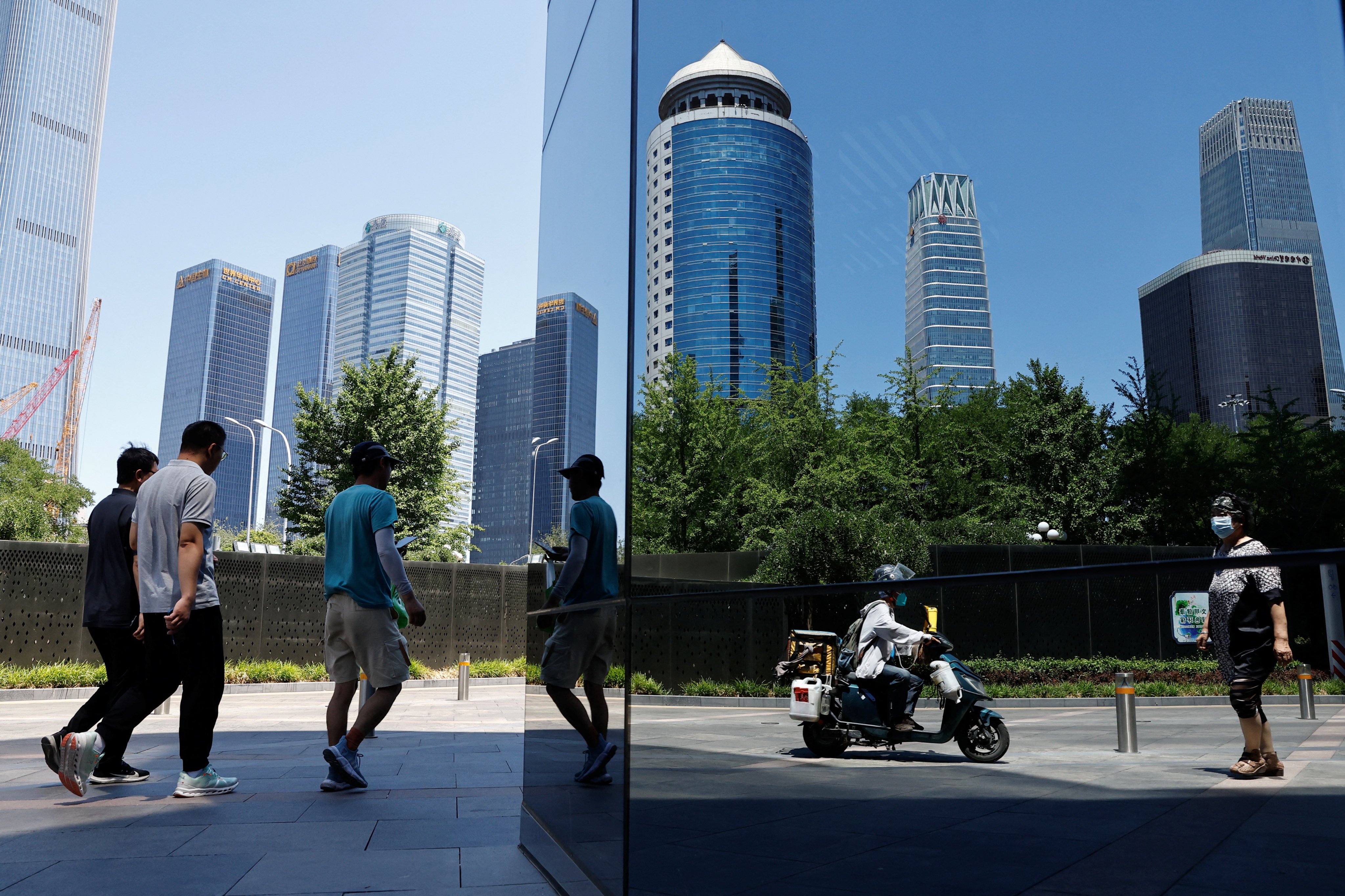 People walk past a building in Beijing’s Central Business District on June 21, 2023. Photo: Reuters