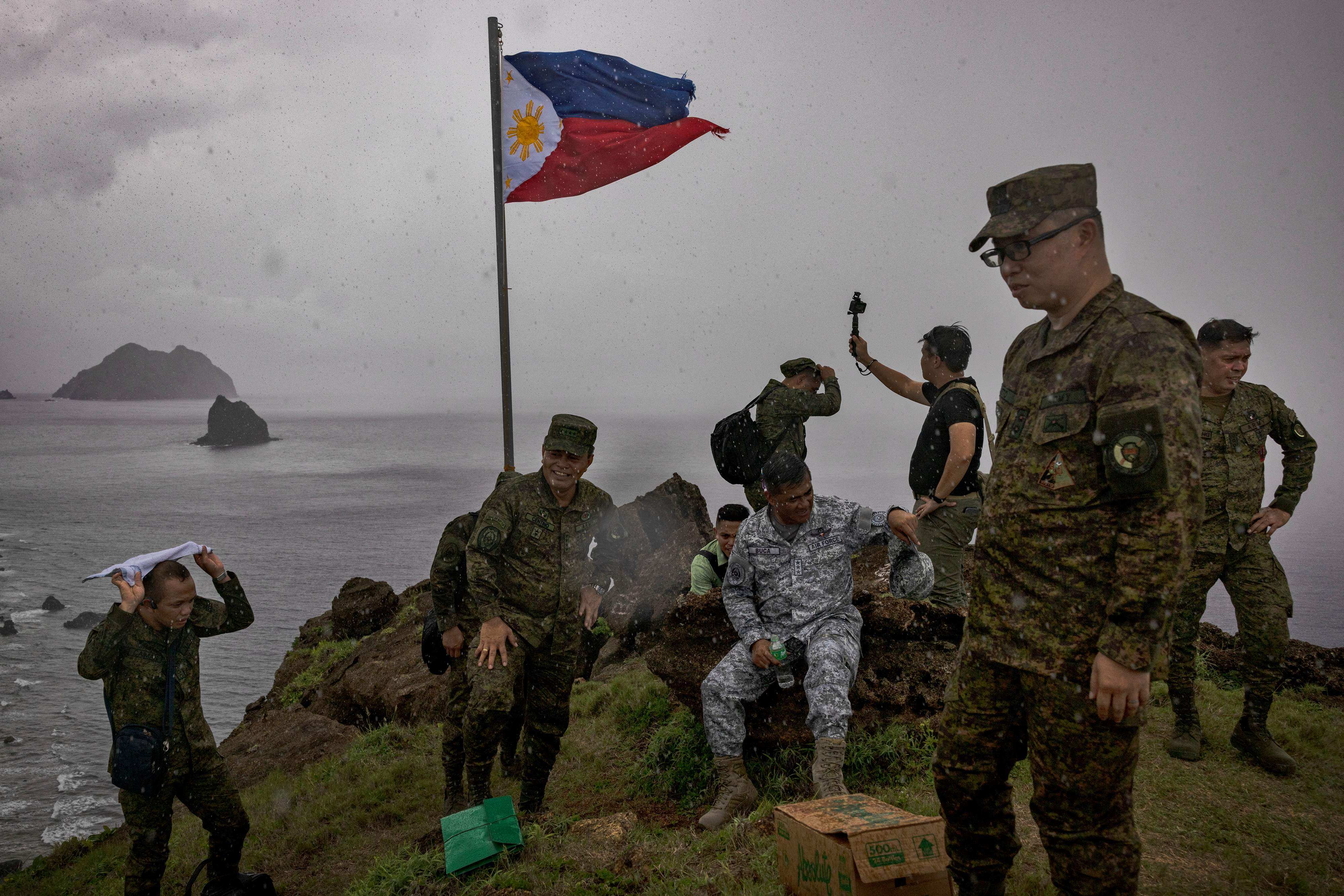 Filipino soldiers take pictures next to a Philippine flag on Mavulis Island, the northernmost of the Batanes islands. Photo: AFP