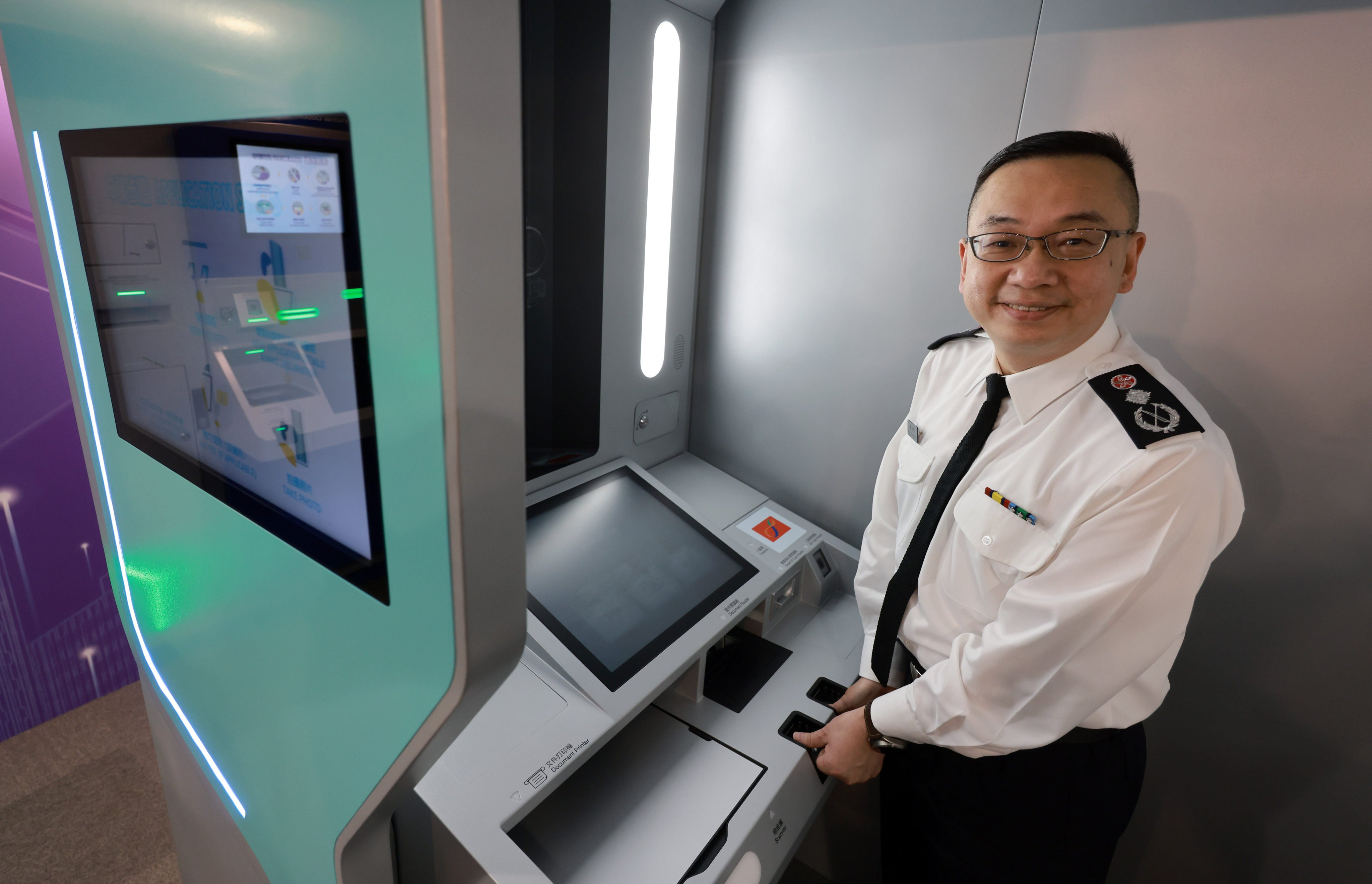 Director of Immigration Benson Kwok    shows off his department’s new self-service document submission kiosk. Photo: May Tse