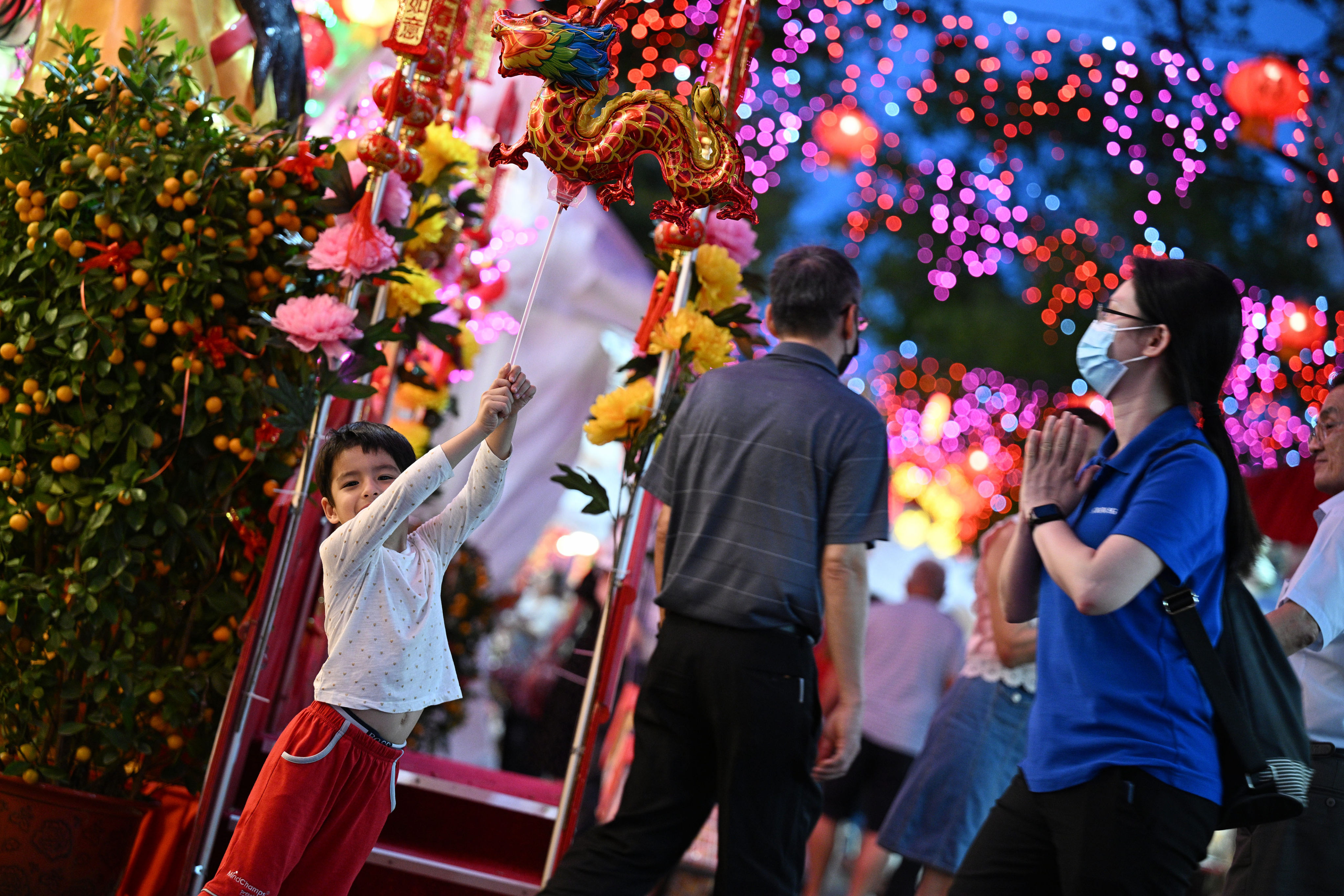 A child poses with a dragon-shaped balloon at a market for Lunar New Year in Singapore. Photo: Xinhua