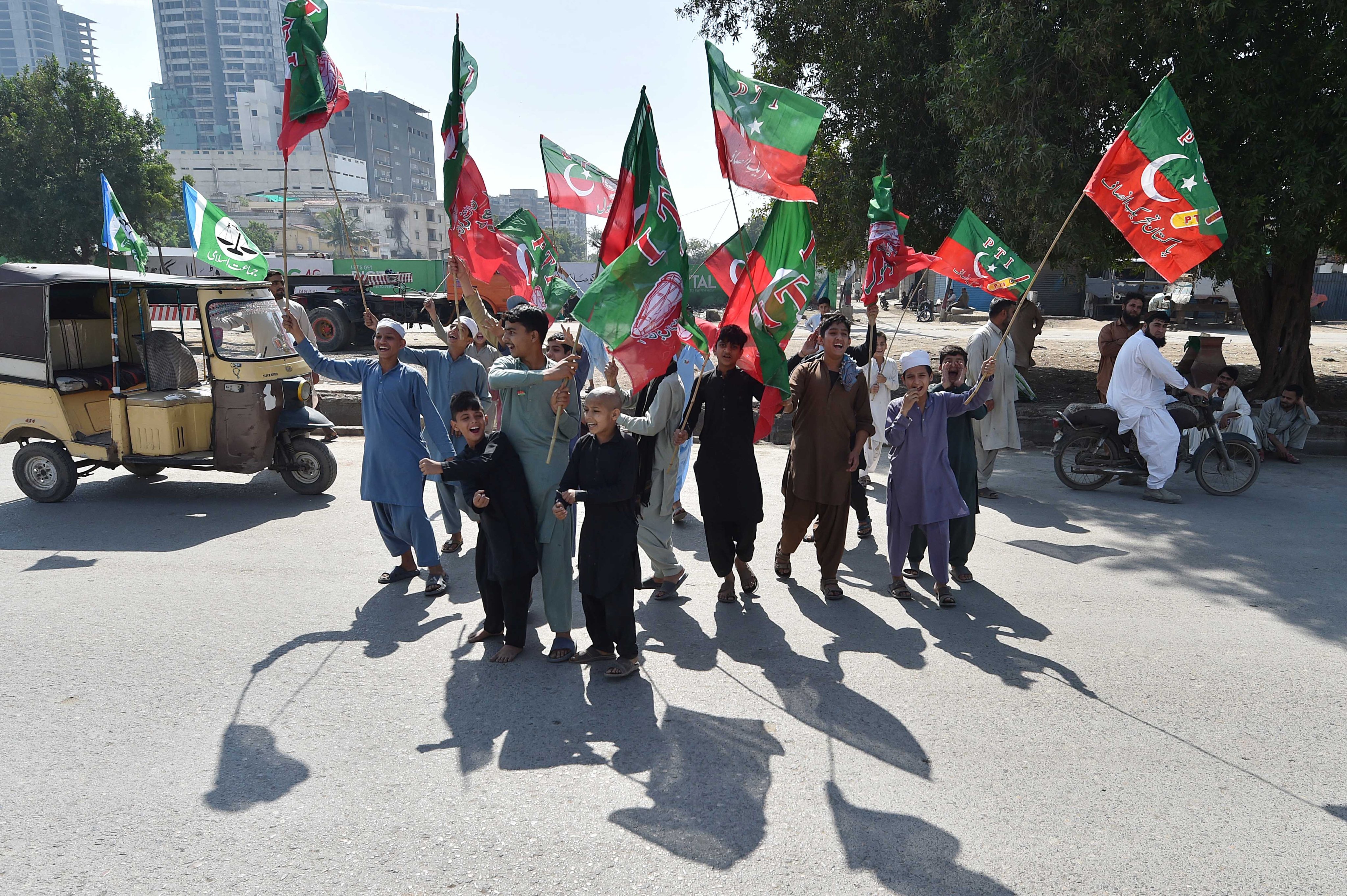 Supporters of convicted former Prime Minister Imran Khan’s Pakistan Tehrik-e-Insaf (PTI) party hold party flags during general elections in Karachi, Pakistan: Photo: EPA-EFE