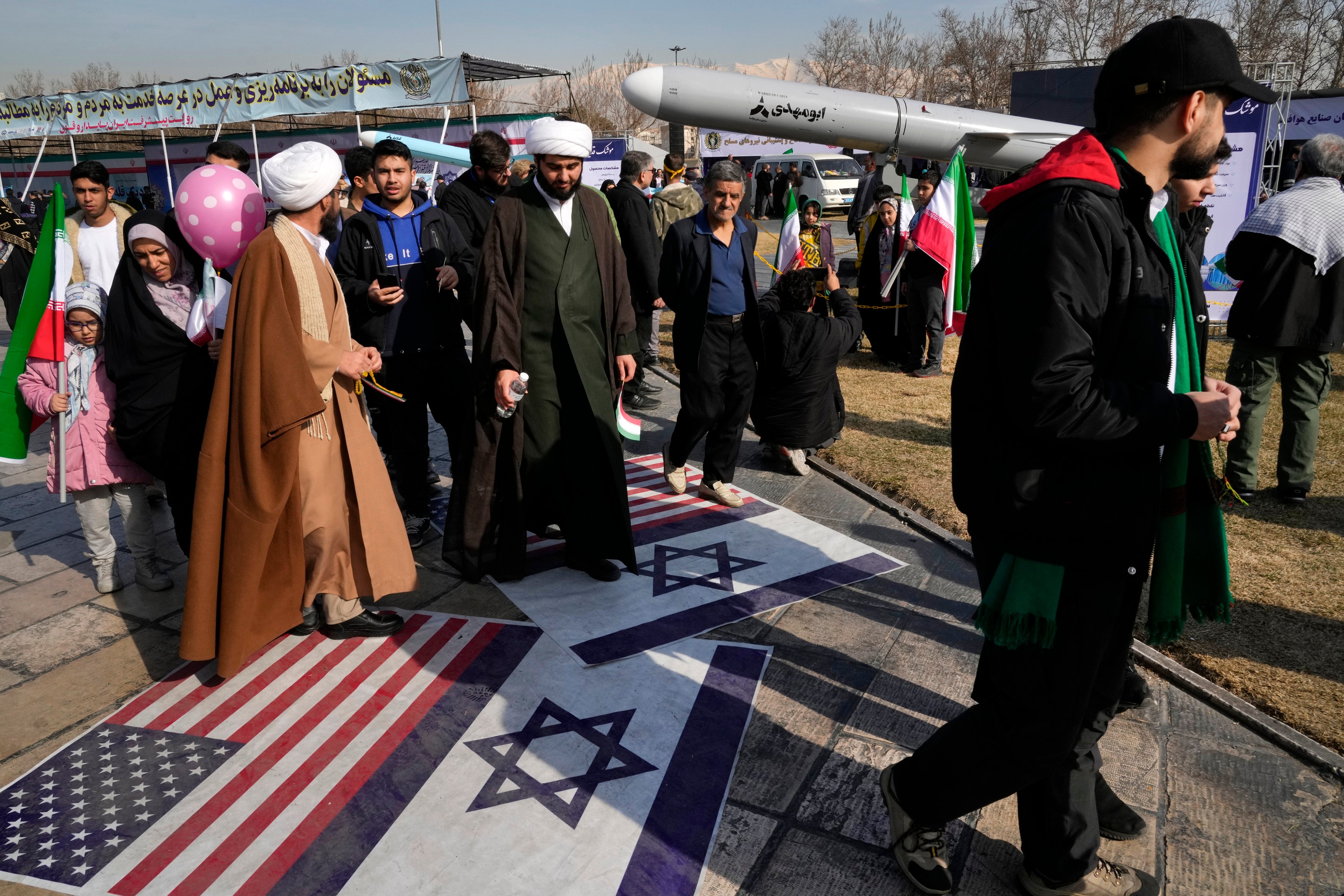 Demonstrators in Tehran walk on representations of the Israeli and US flags on Sunday during Iran’s annual rally commemorating the 1979 Islamic Revolution. Photo: AP