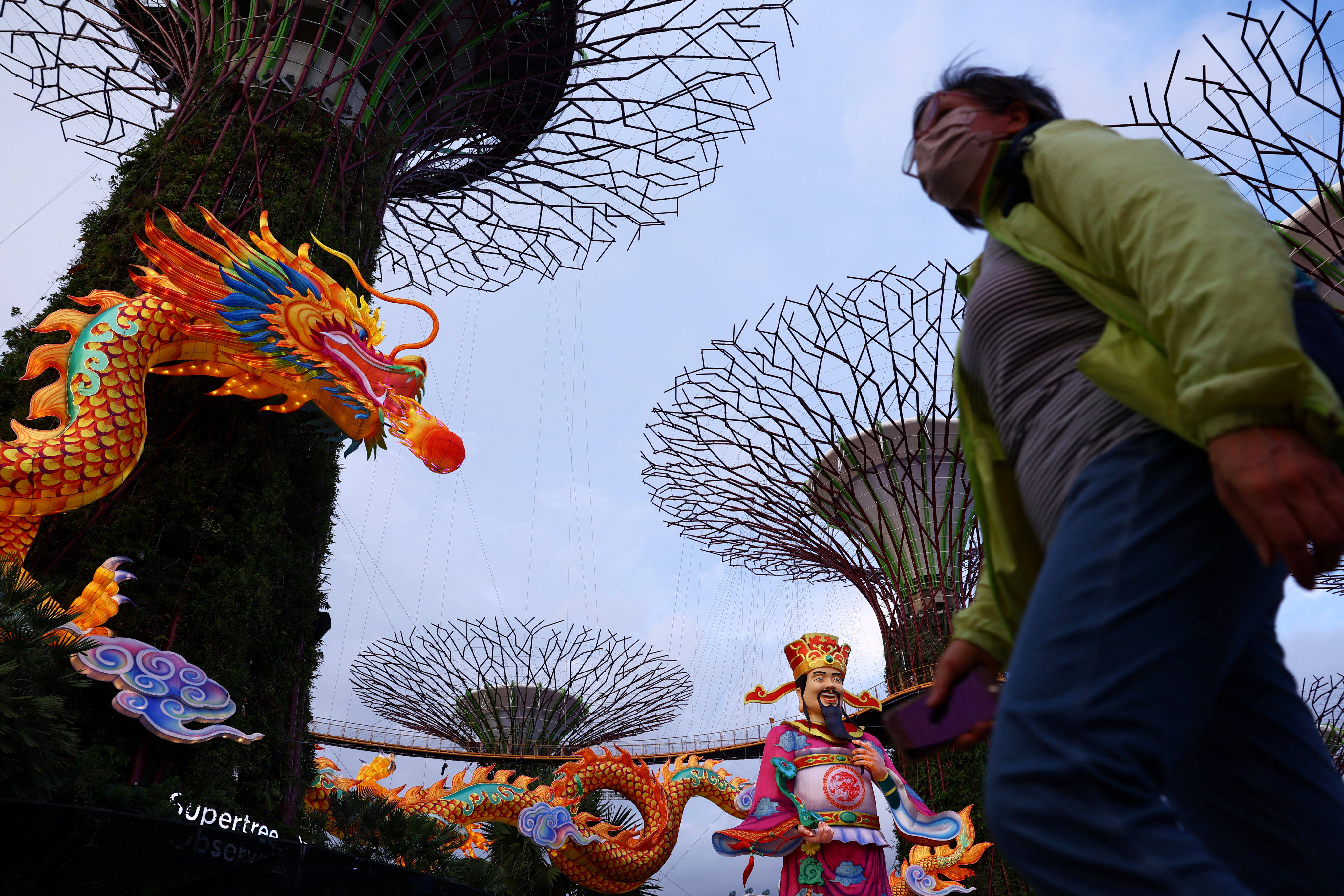 People pass the God of Fortune statue and dragon sculpture in Singapore. Photo: Reuters