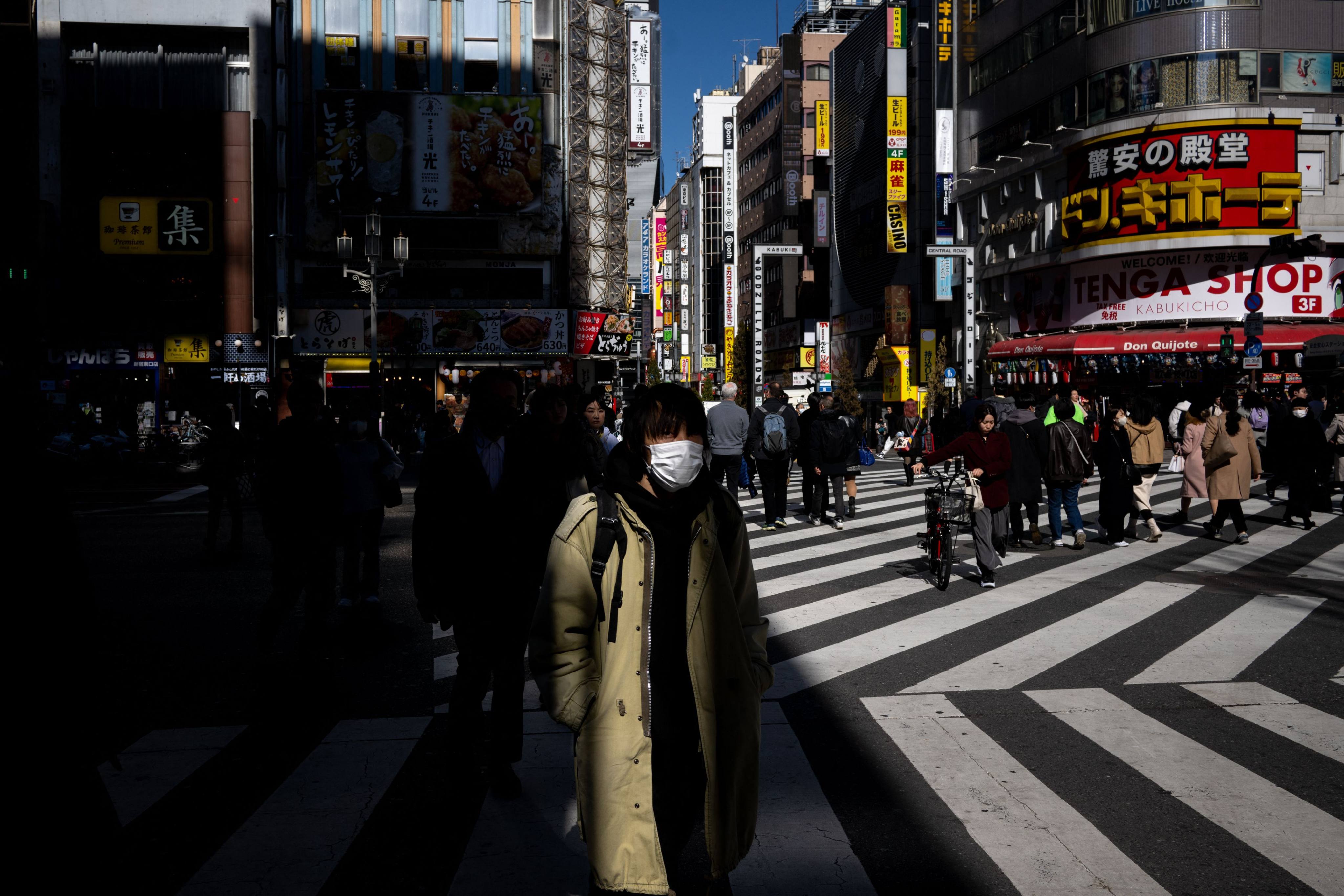 Pedestrians walk in Shinjuku district of Tokyo. The government has maintained that Japan is not in a state of deflation, but has yet to officially declare its end. Photo: AFP