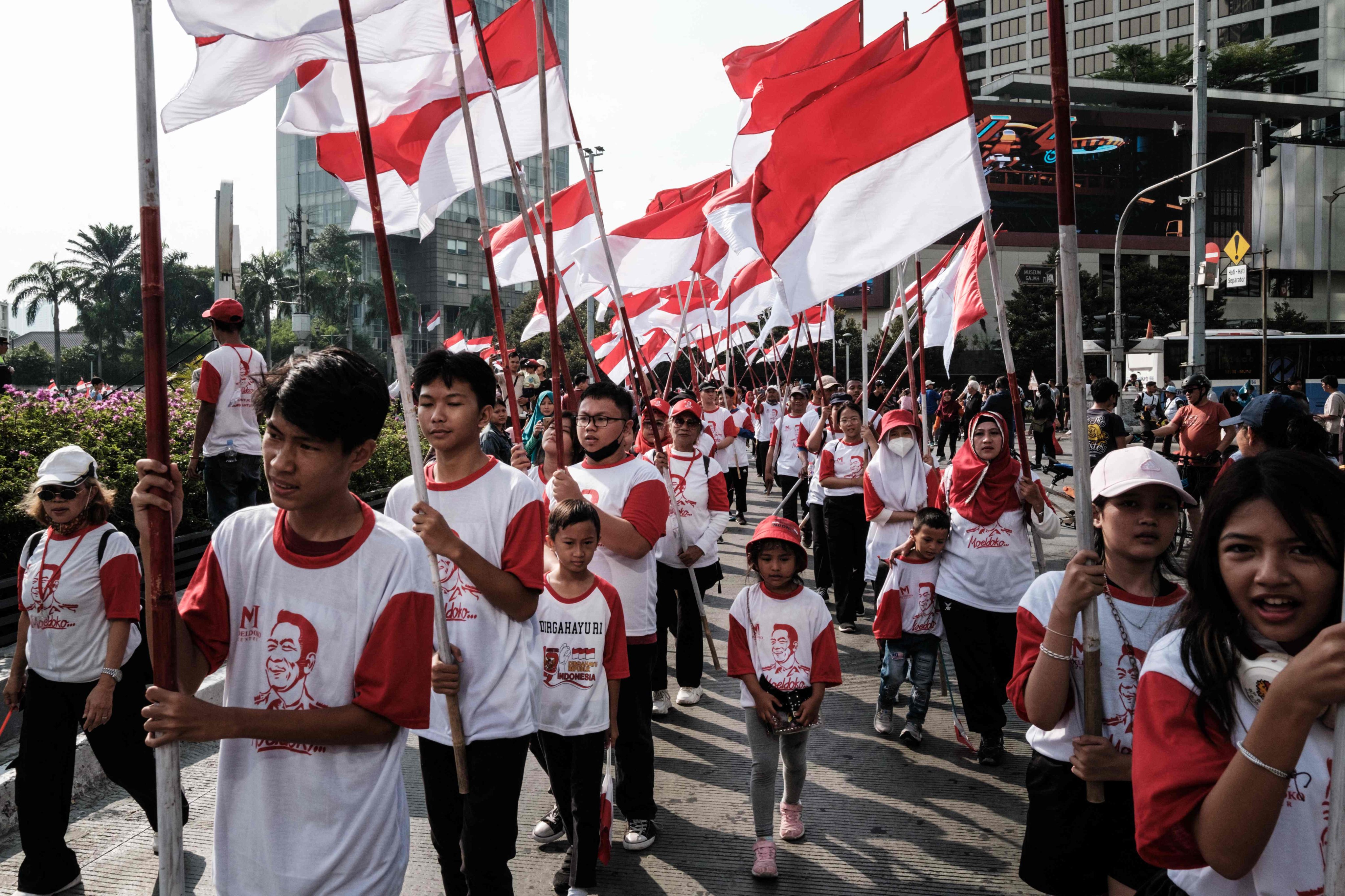 People hold flags of Indonesia at the Selamat Datang Monument ahead of the 78th Independence Day in Jakarta on August 13, 2023. Photo: AFP