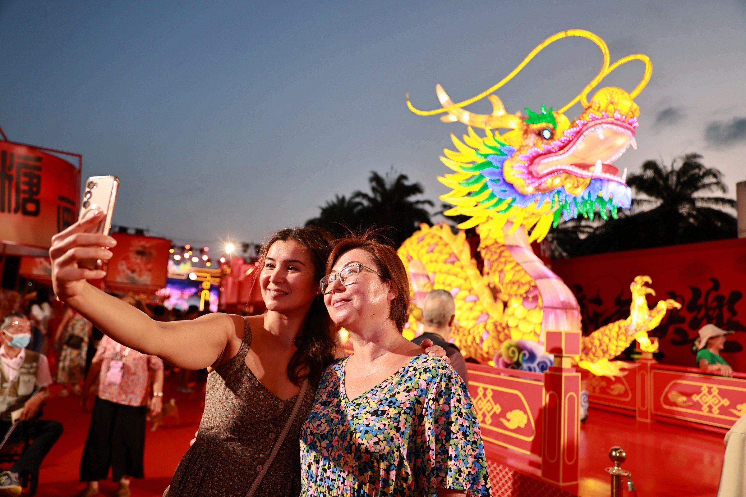 Tourists take selfies with a lantern in the resort city of Sanya in China’s Hainan province on February 5. Photo: Xinhua