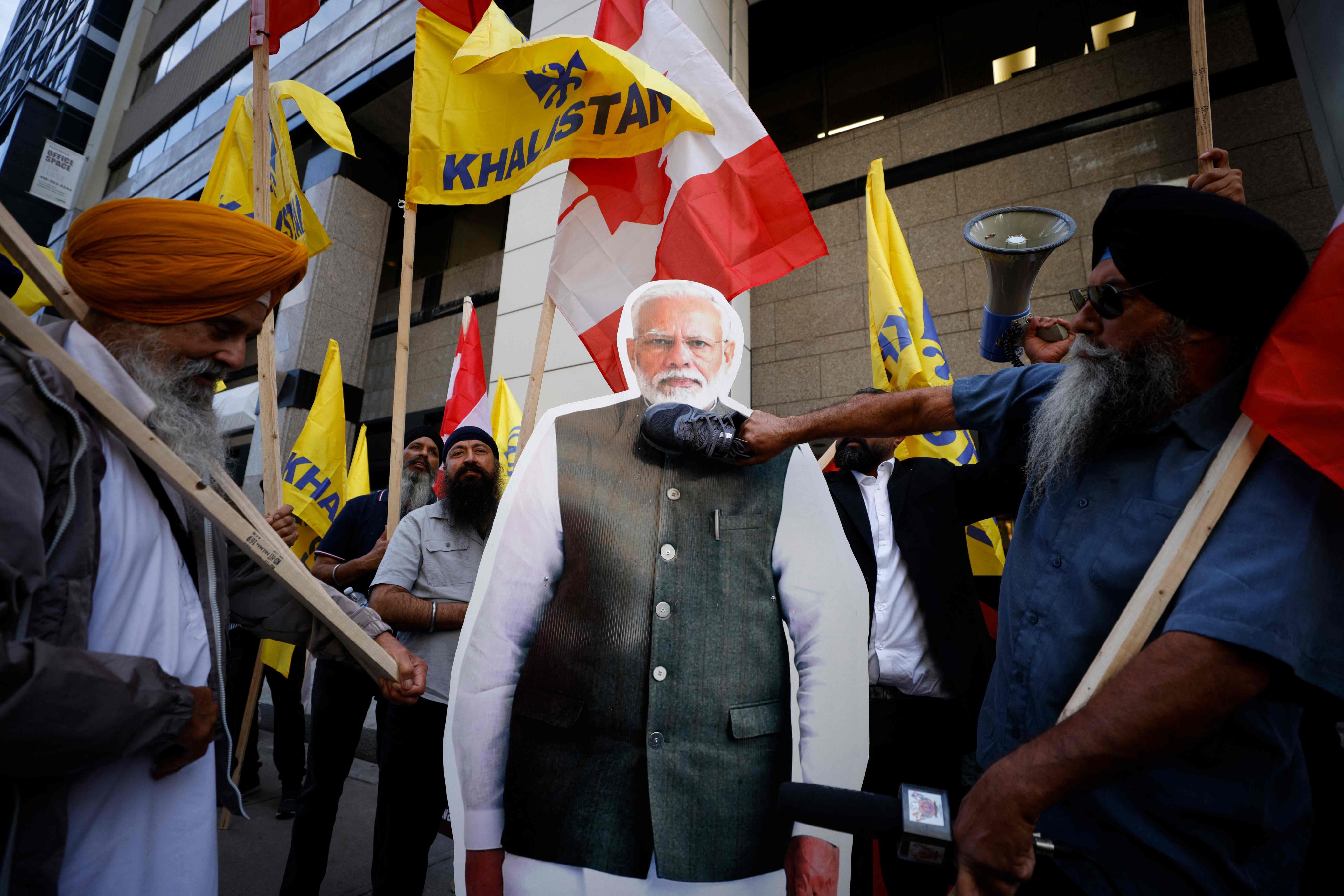 Protesters use their shoes to hit a placard depicting Indian prime minister Narendra Modi during a Sikh rally outside the Consulate General of India in Toronto. Photo: AFP