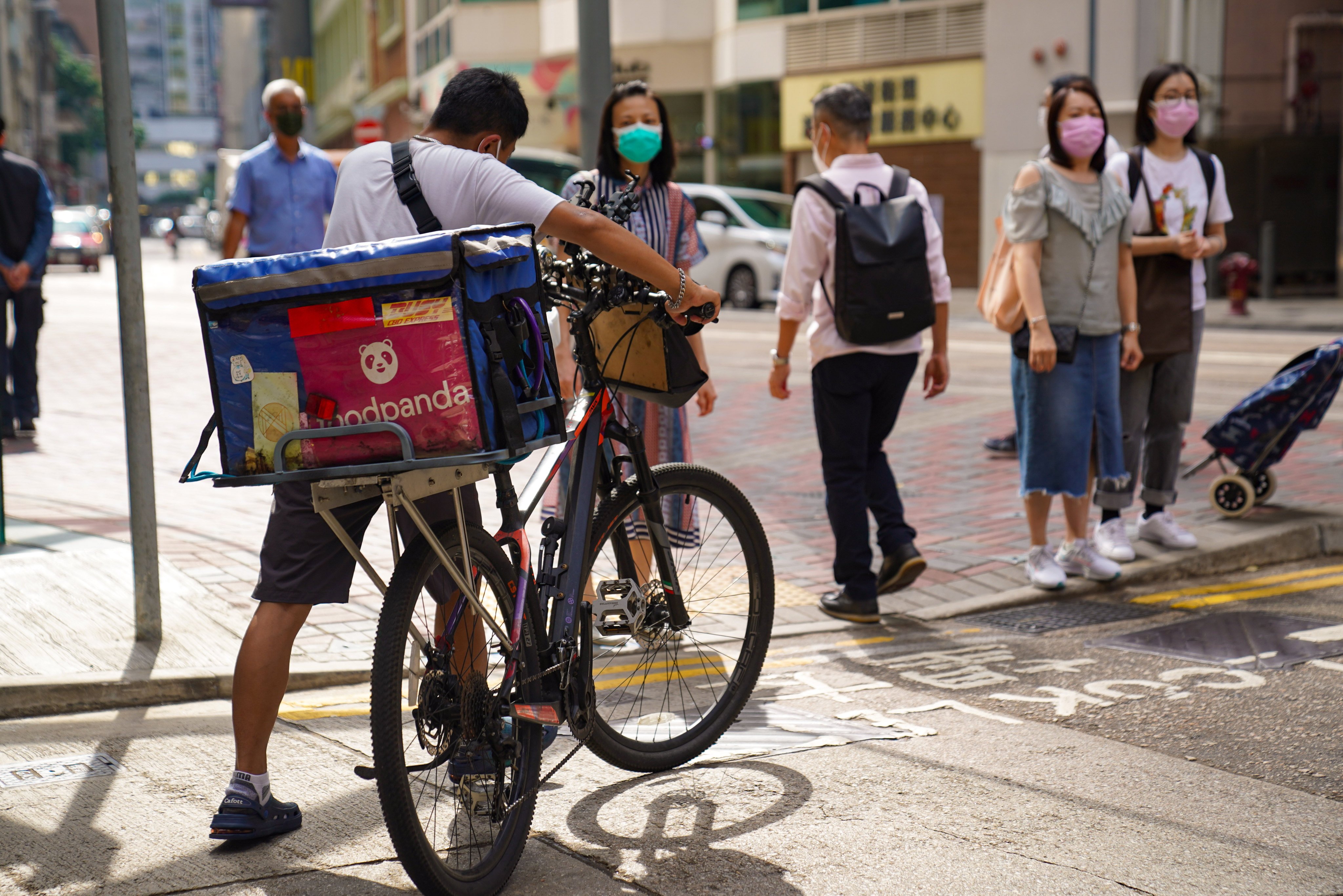 A man pushes a bicycle with a food delivery bag in Causeway Bay. The Consumer Council ran a test of 56 orders through six platforms during lunch and dinner sessions in Hong Kong’s 11 districts in December. Photo: Sam Tsang