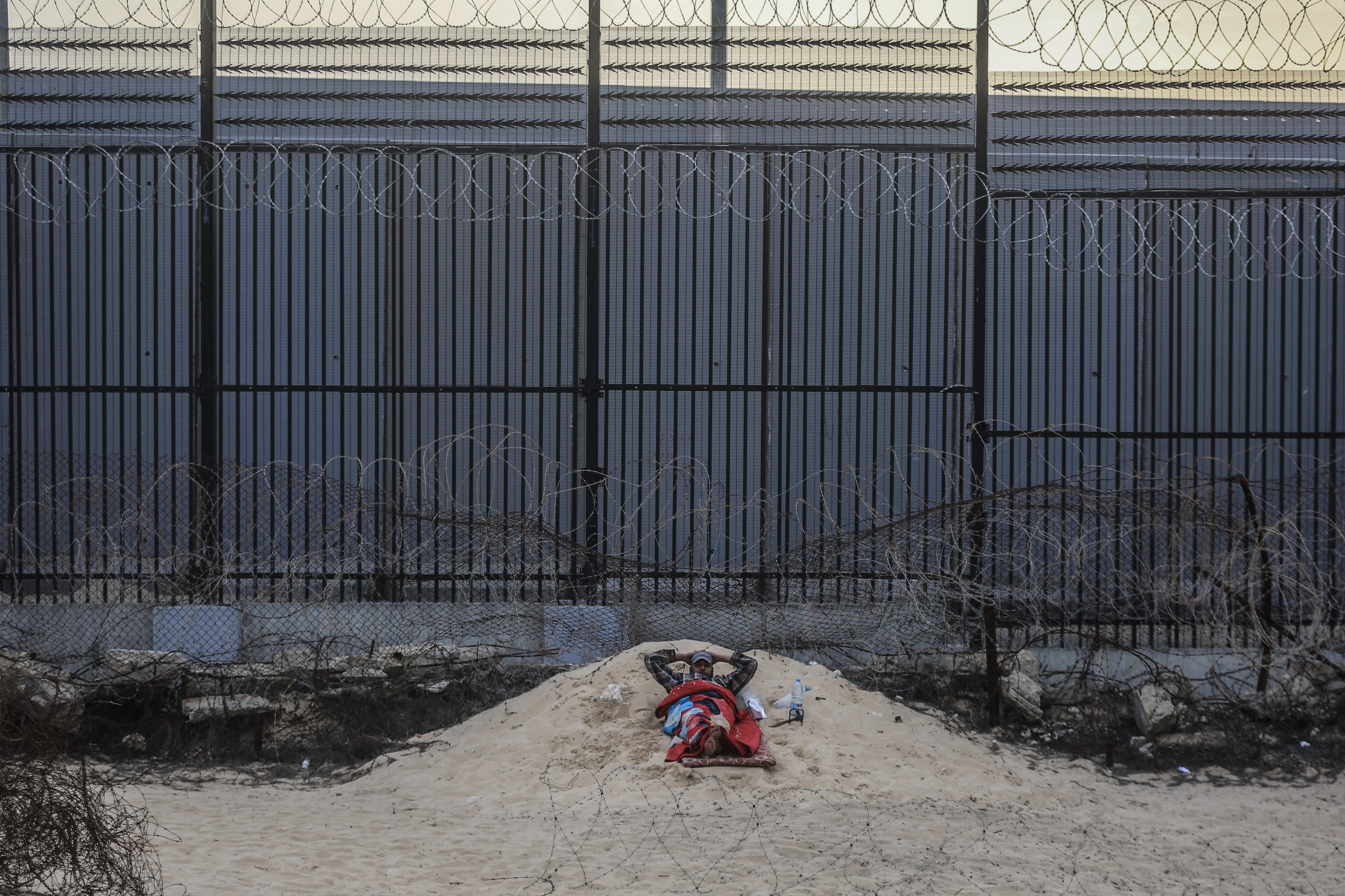 A Palestinian man rests near the wall separating Egypt and the Gaza Strip. Photo: dpa