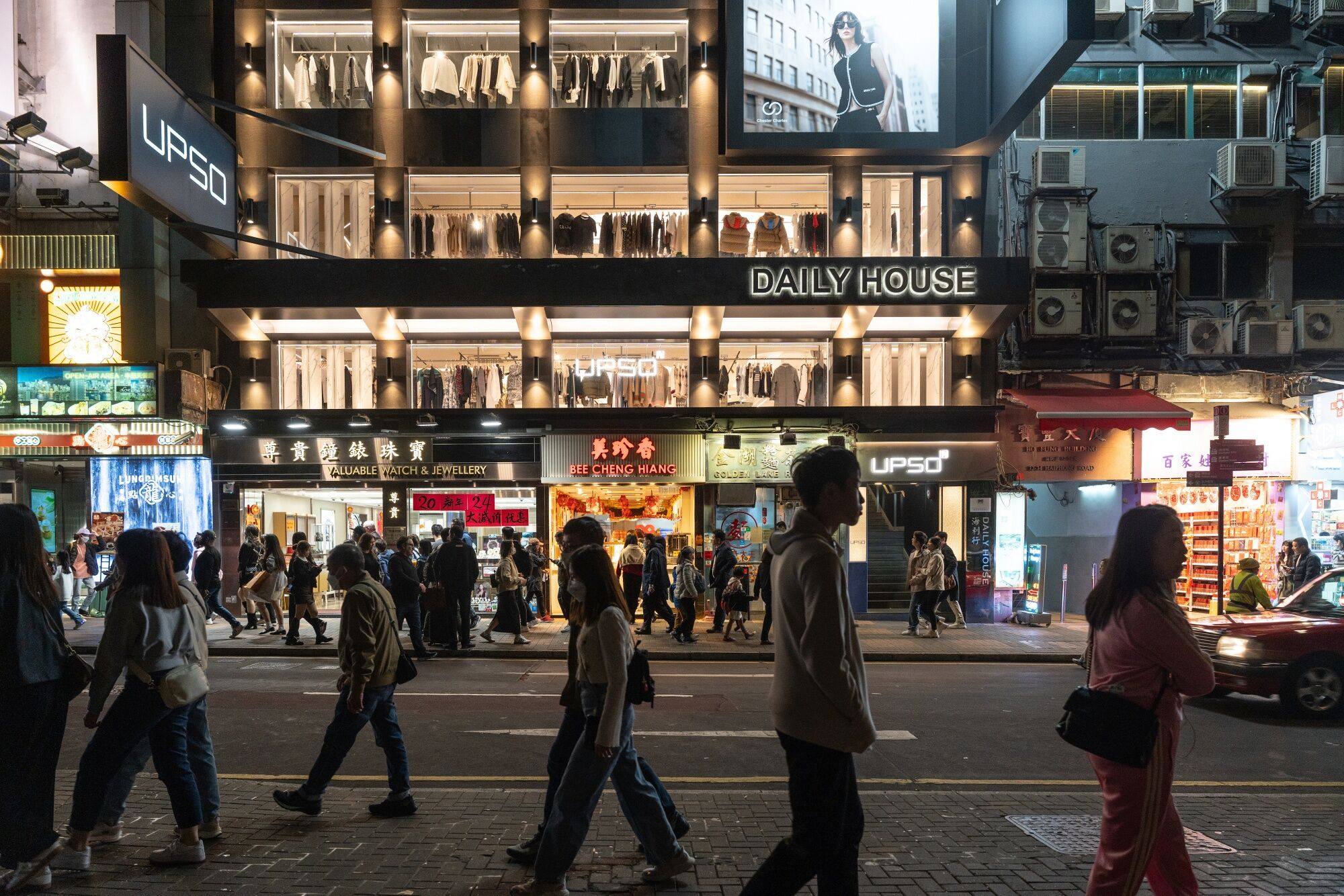Pedestrians walk past stores in Hong Kong’s Tsim Sha Tsui district during the Lunar New Year holiday on February 12. Hong Kong should invest in improving the city’s public areas, rather than spend money on trying to revitalise our traditional shopping and nightlife scene. Photo: Bloomberg