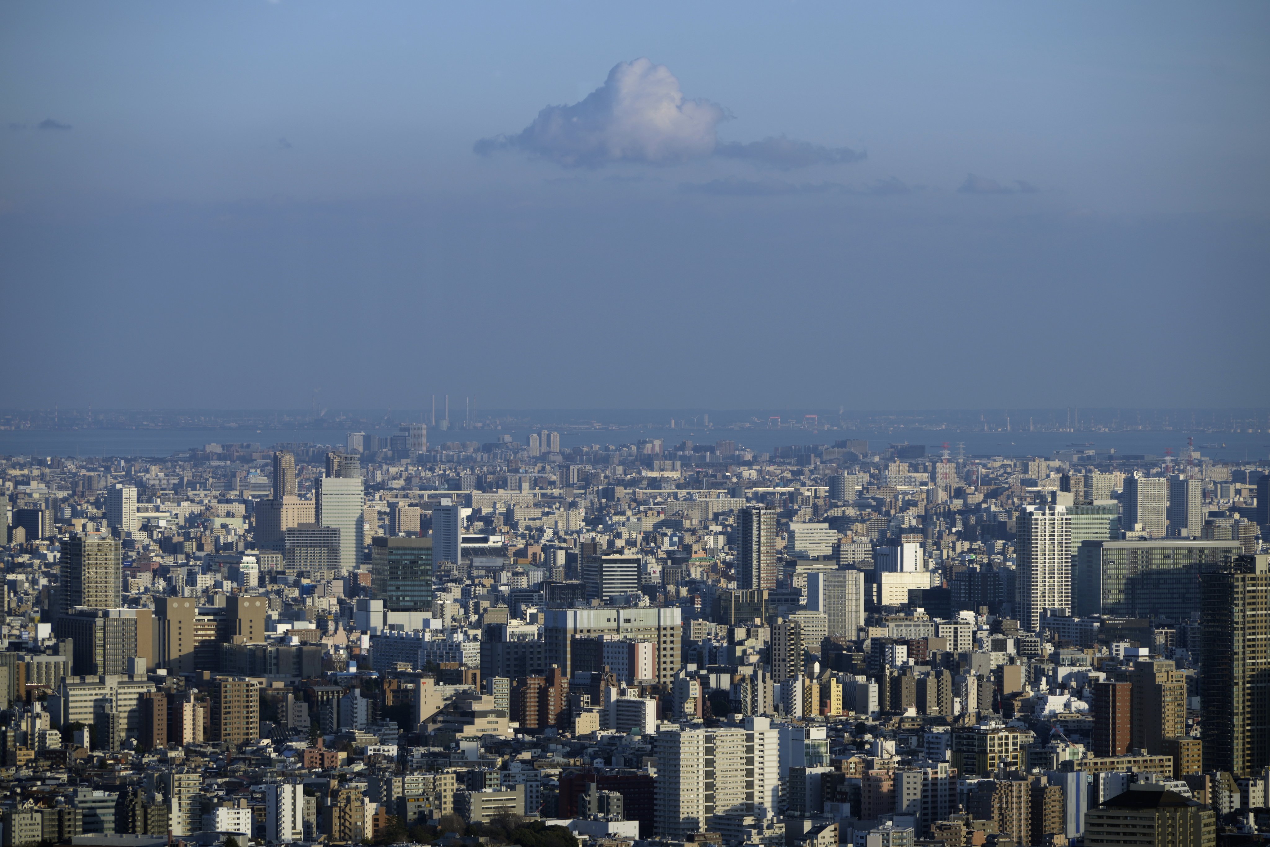 A cloud is seen over the Tokyo cityscape on February 8. Officials and analysts talking up the economy may have succeeded in projecting an image of renewed vigour, but many challenges remain. Photo: EPA-EFE