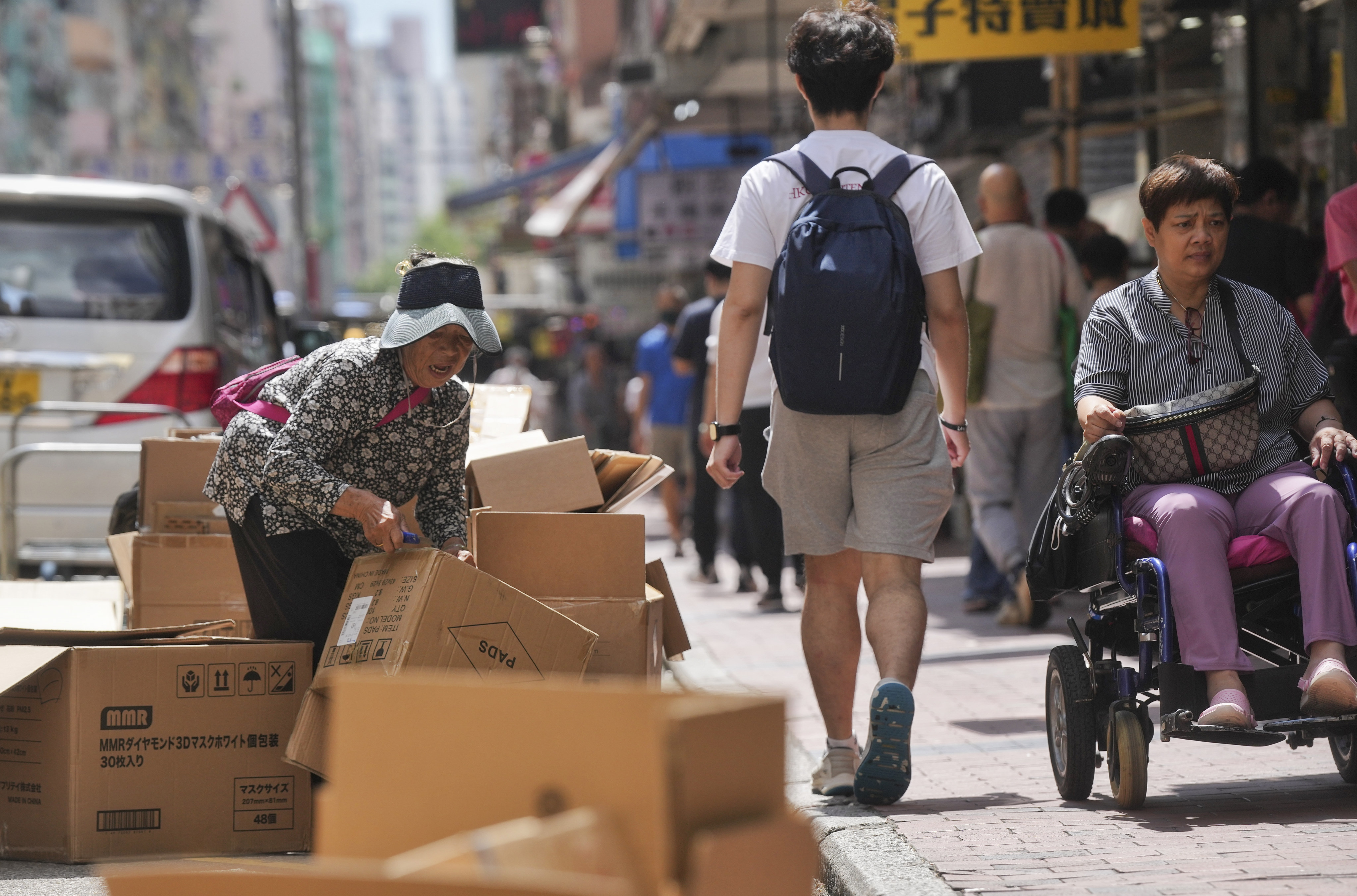 An elderly woman sorts out abandoned cardboard boxes for resale in Sham Shui Po. The city’s poverty rate in 2020 was 23.6 per cent, government statistics have shown – equivalent to 1.65 million people. Photo: Elson LI