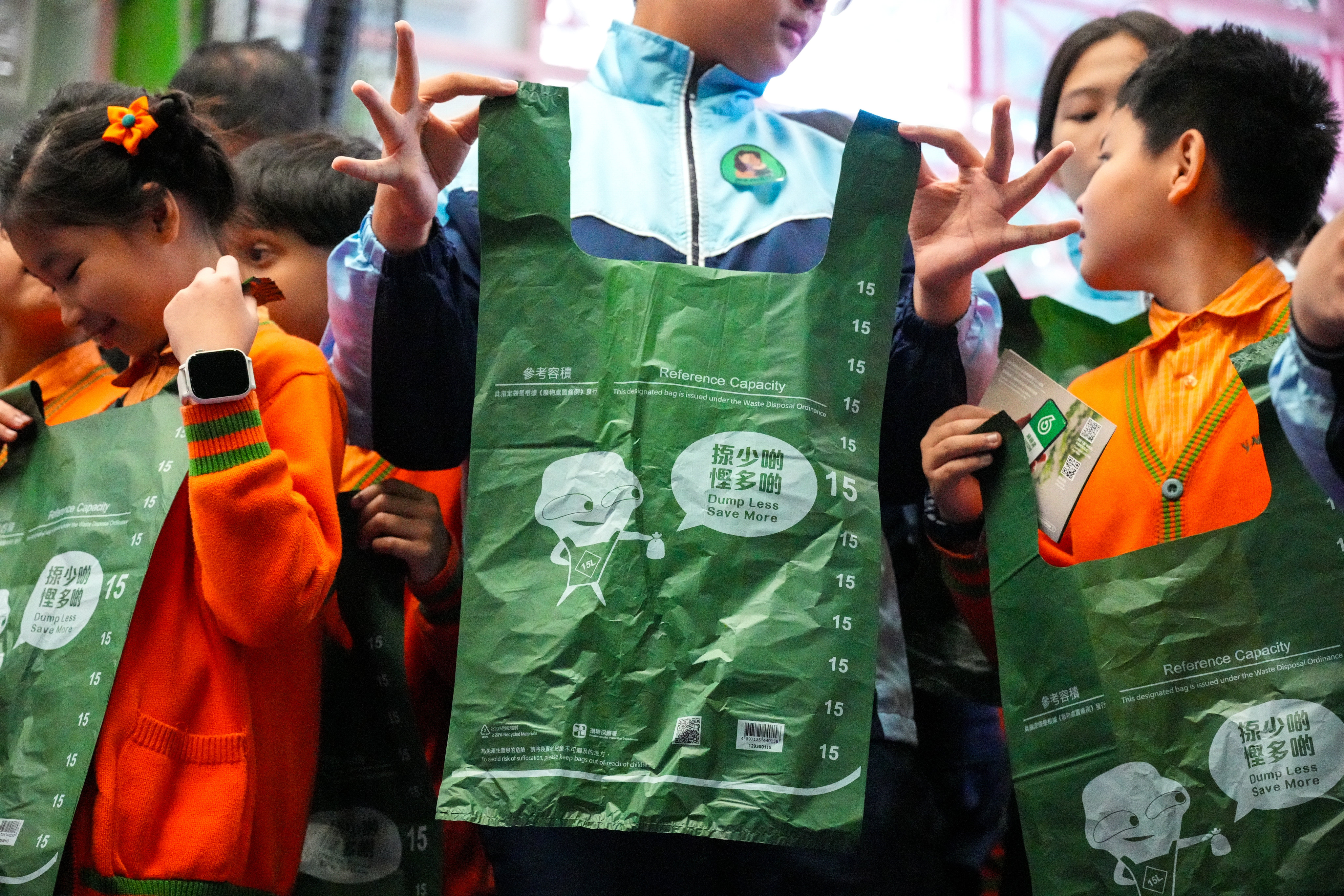 Pupils hold up designated bags at a promotional event for the coming waste-charging scheme. Photo: Eugene Lee